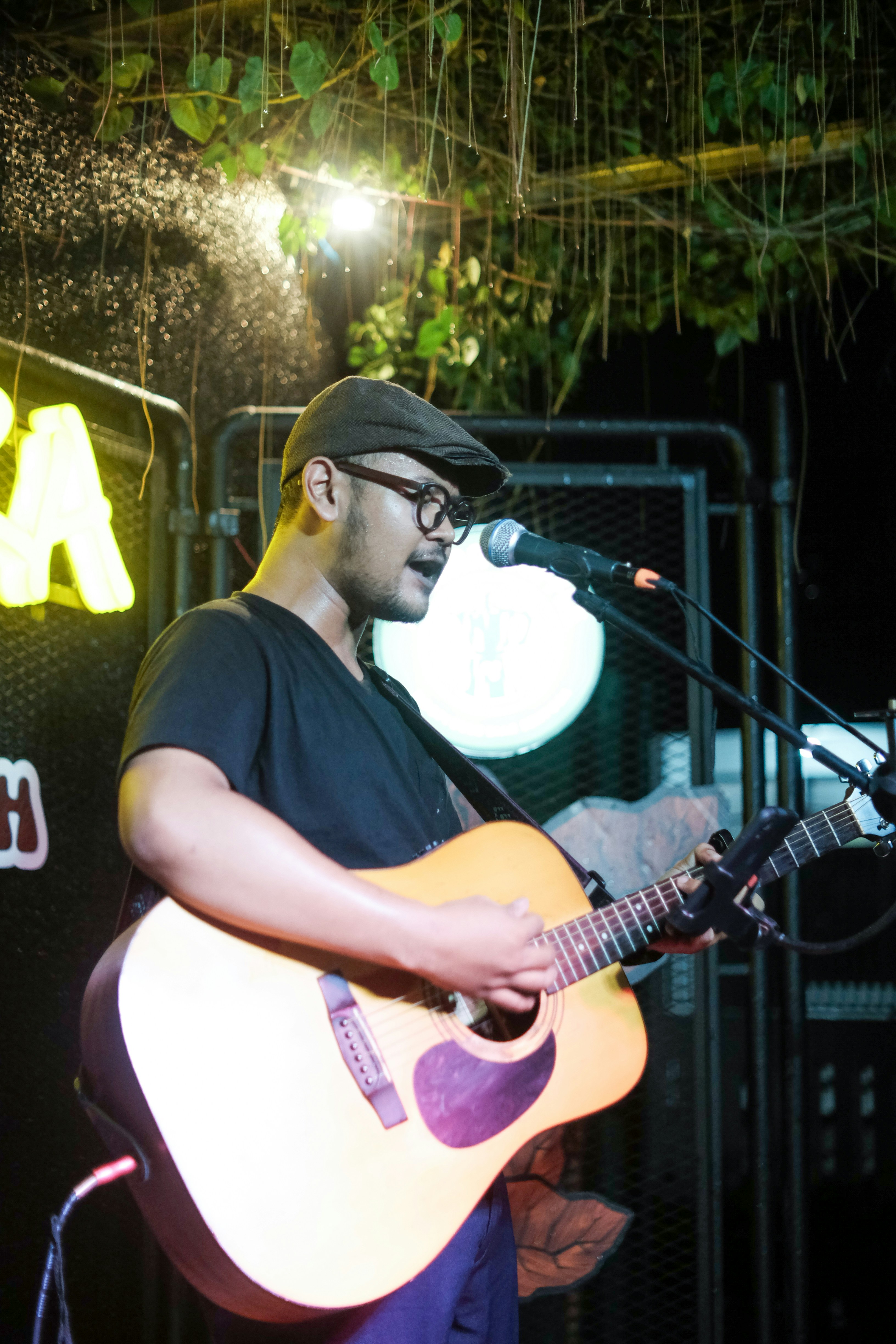 seorang pria bermain gitar di depan mikrofon