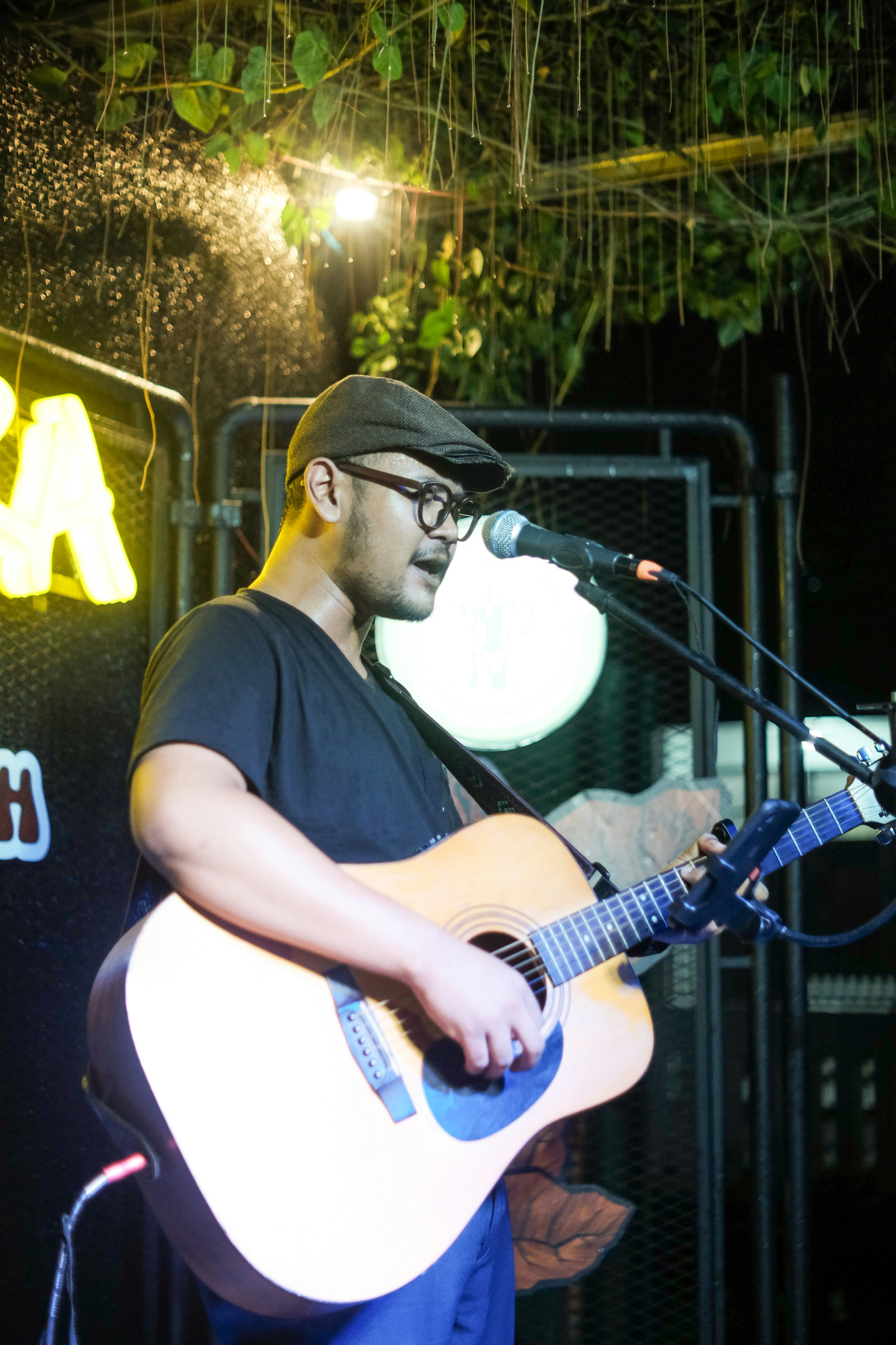 seorang pria bermain gitar di depan mikrofon