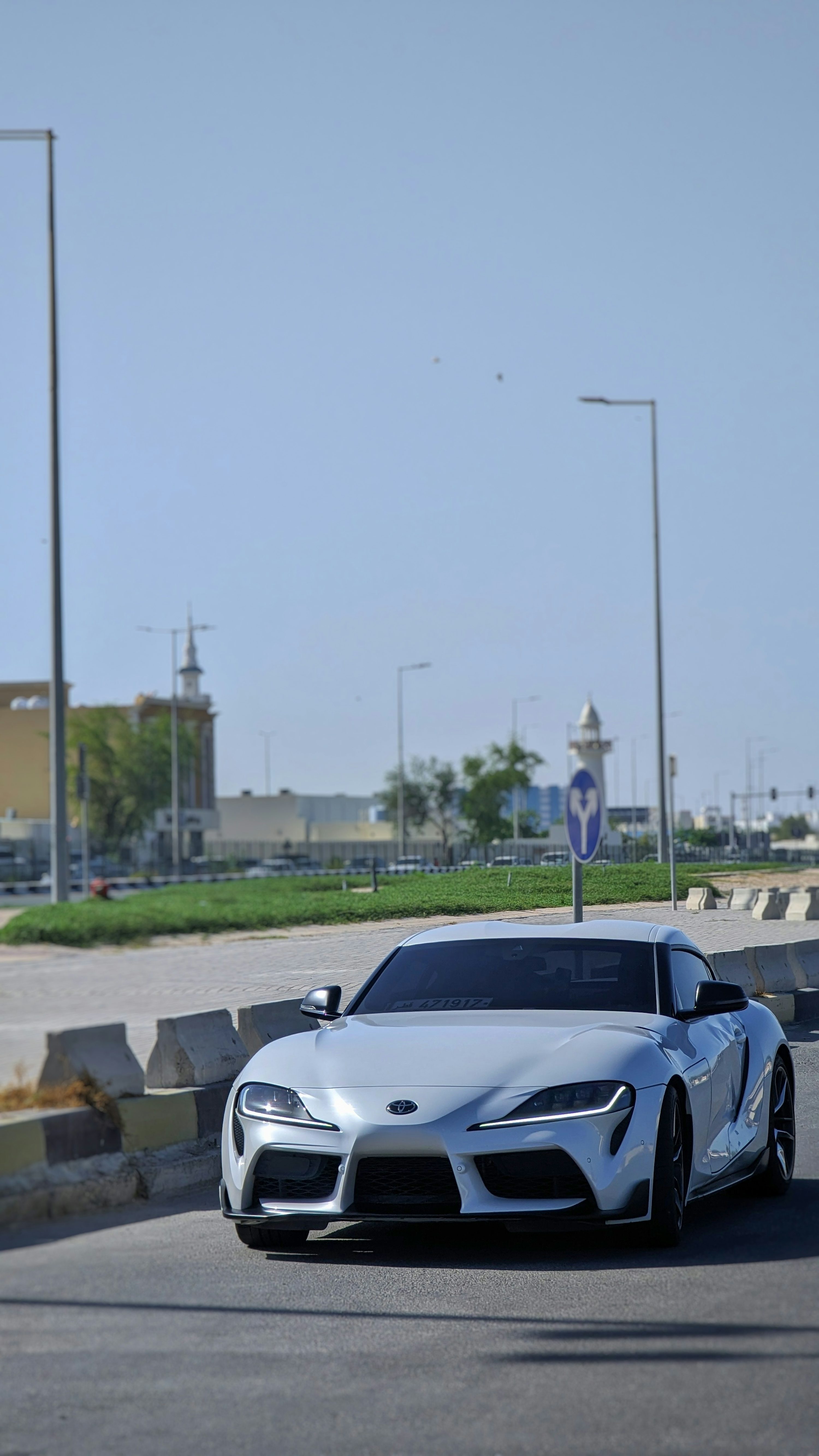 a white sports car driving down a street