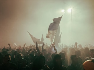 a crowd of people standing around a flag