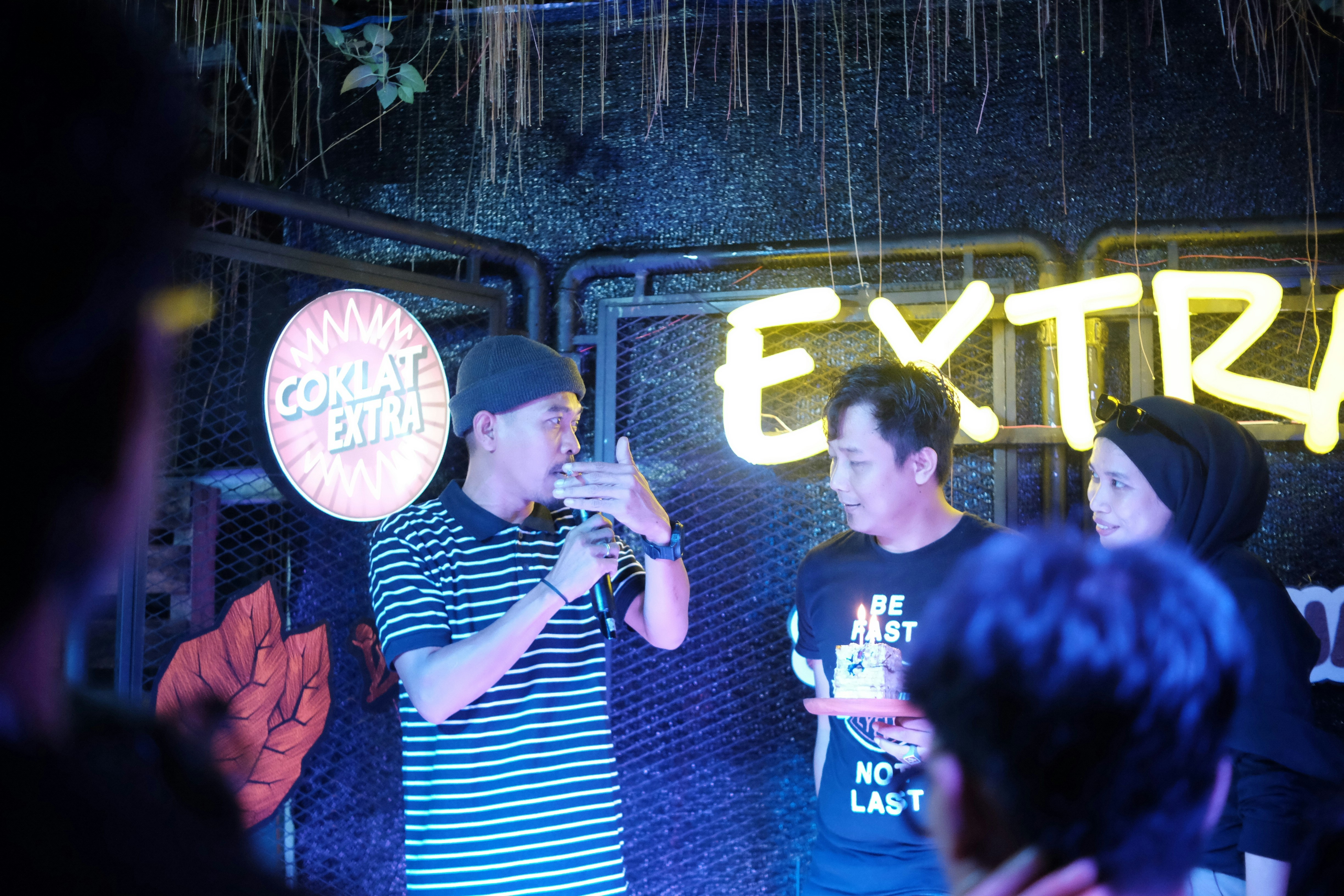 Man celebrating birthday at a party with colourful lights, happy expression