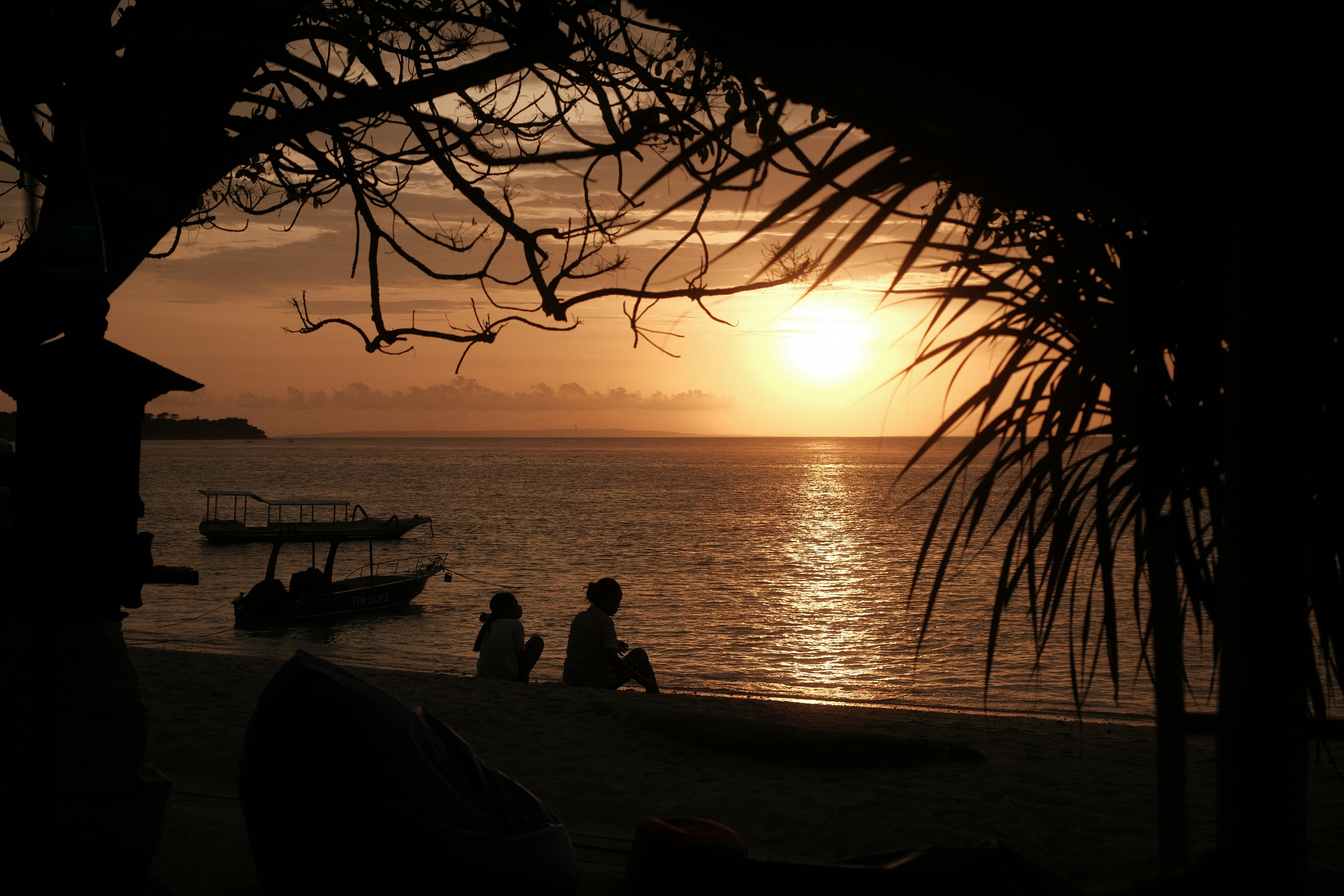 un gruppo di persone sedute in cima a una spiaggia vicino all'oceano