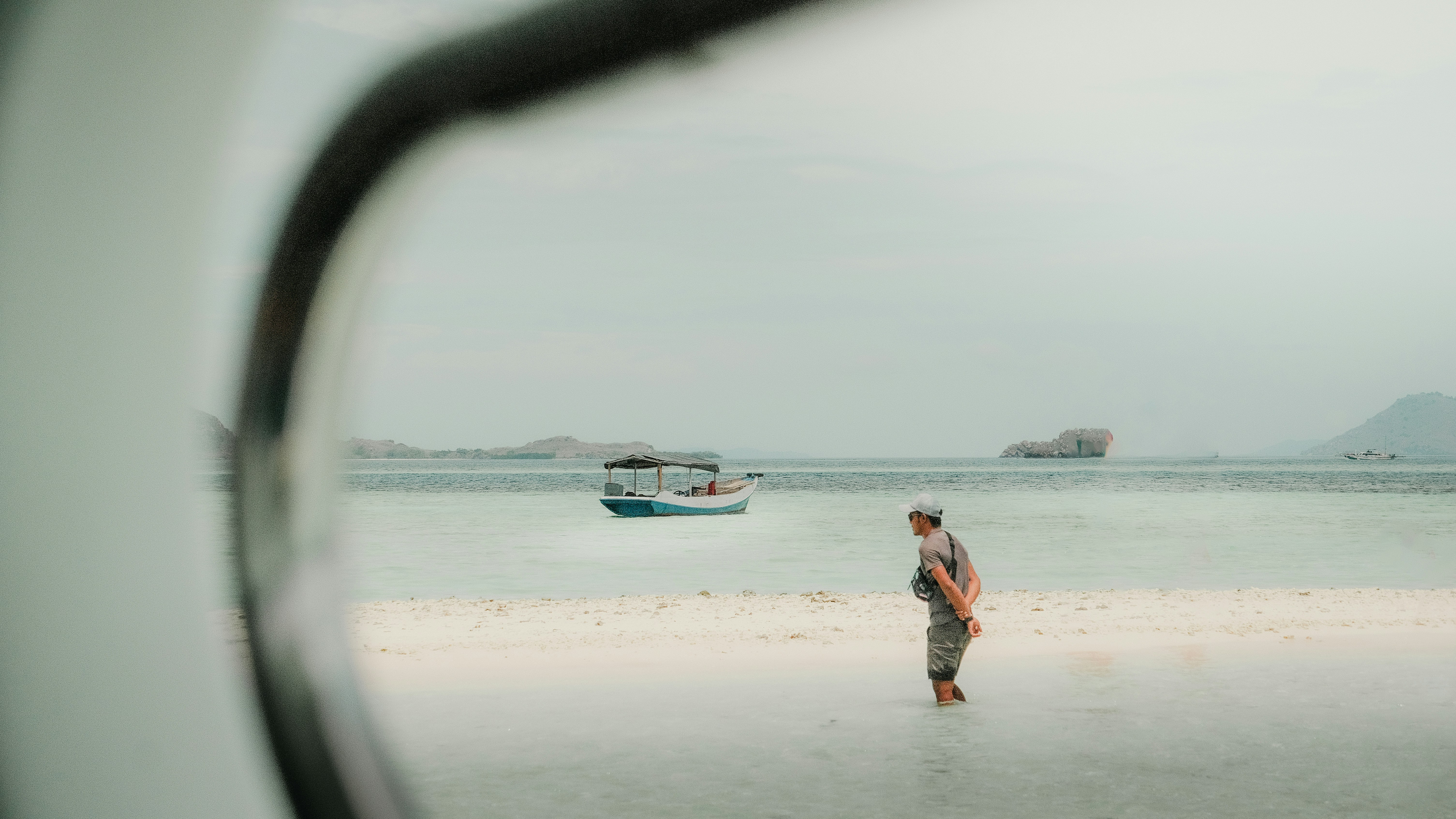 un uomo in piedi su una spiaggia accanto a una barca