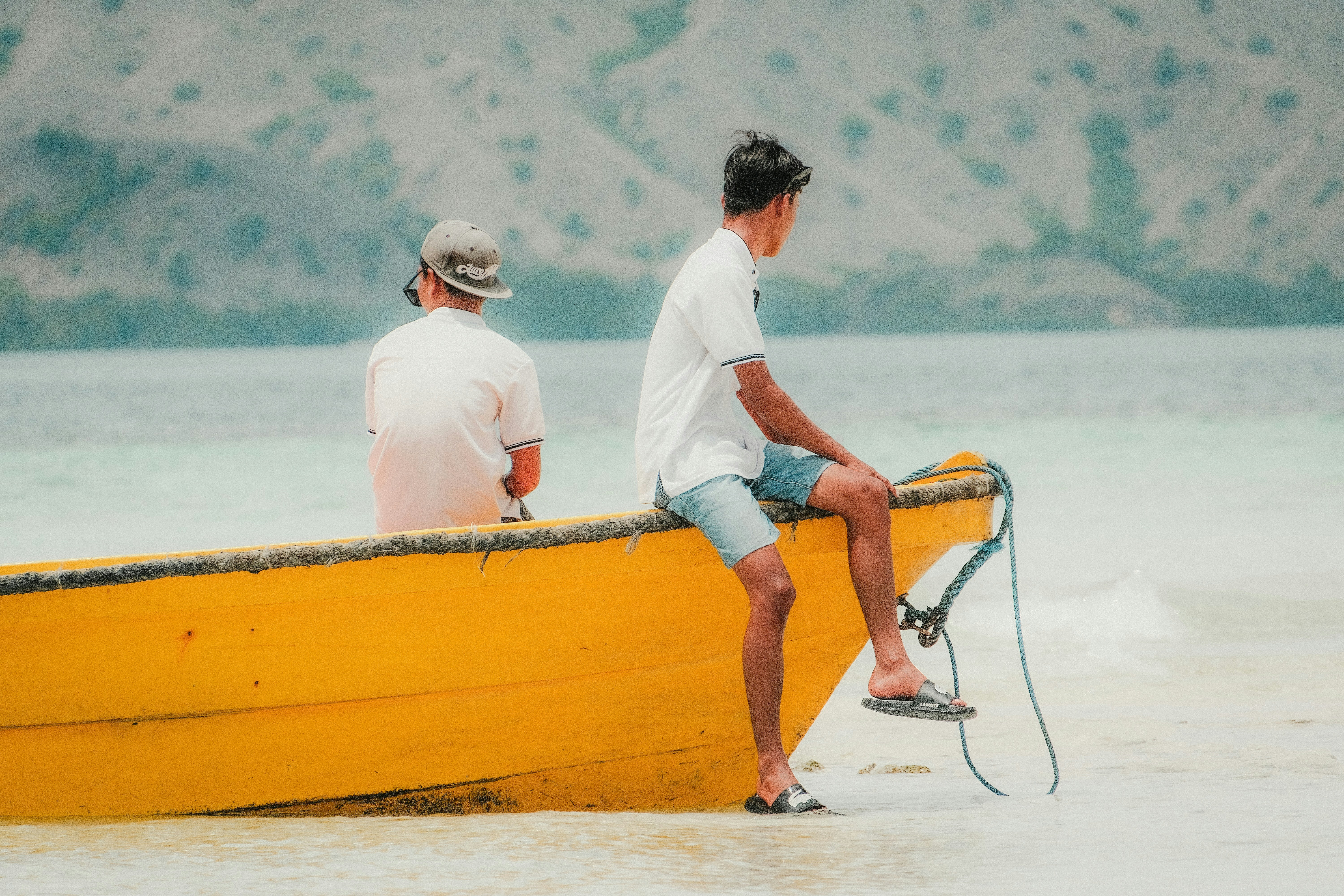 una coppia di uomini seduti in cima a una barca gialla