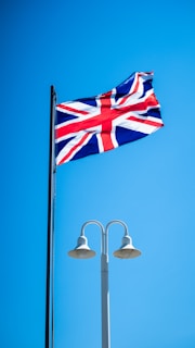 a british flag flying high in the blue sky
