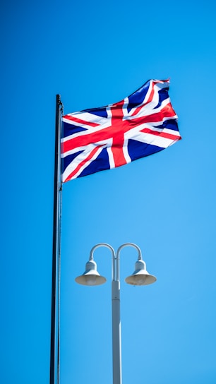 a british flag flying high in the blue sky