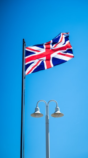 a british flag flying high in the blue sky