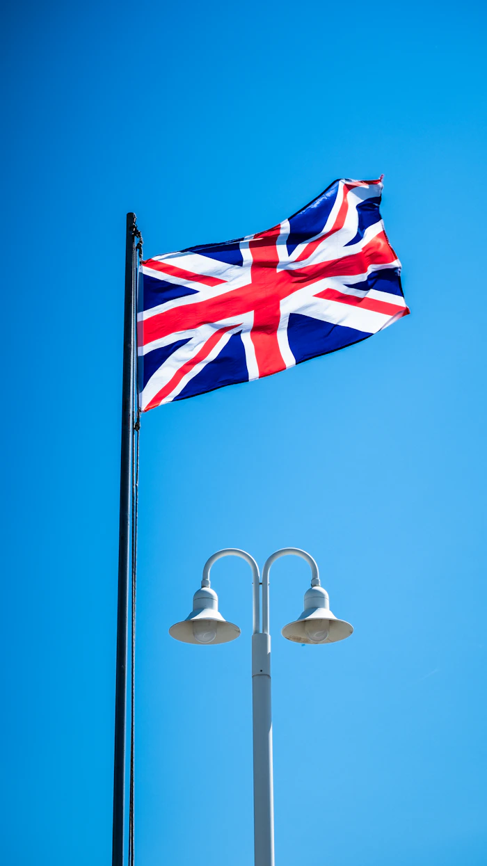 A Union Jack flag flying against a blue sky