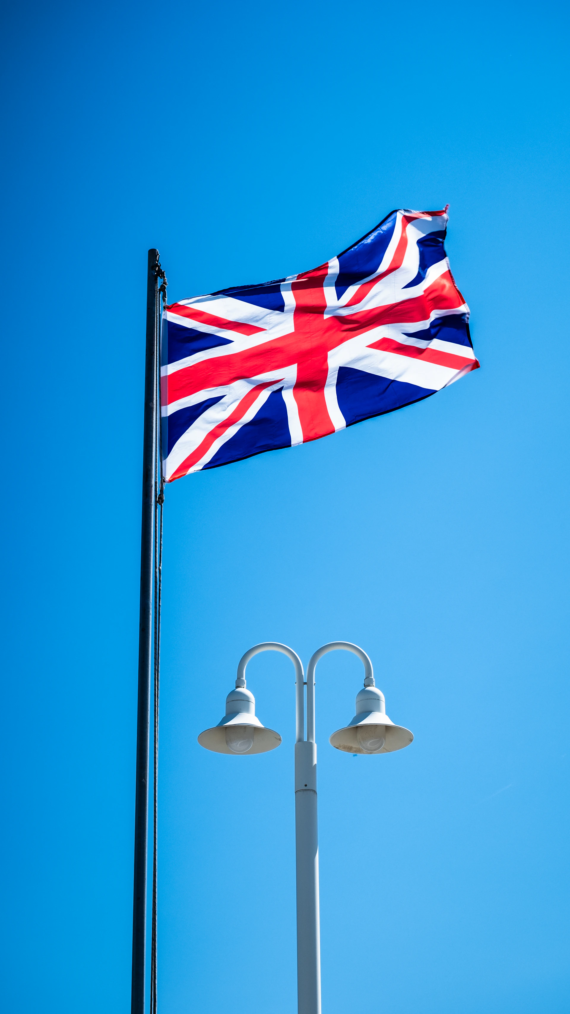 a british flag flying high in the blue sky