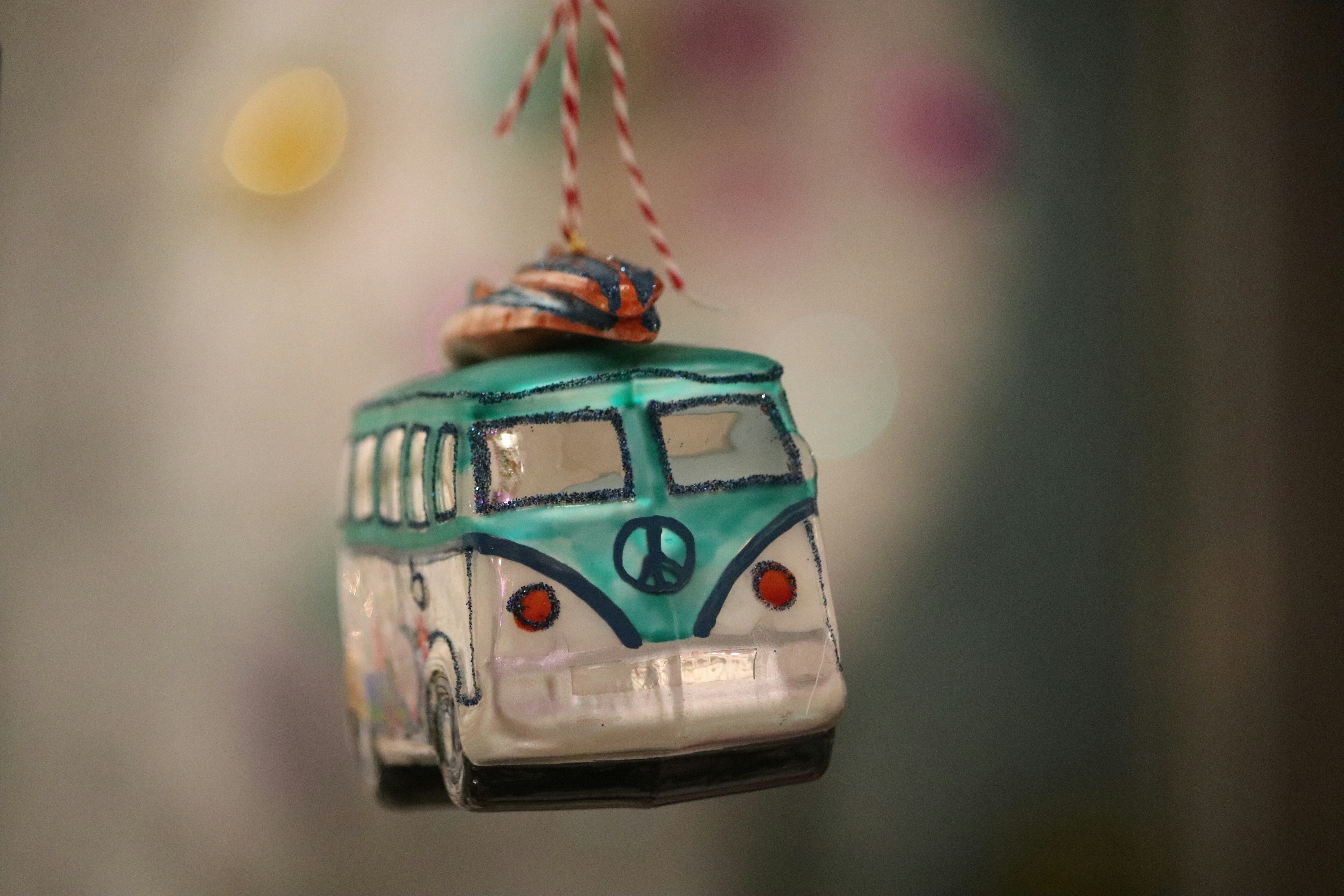 a blue and white bus ornament hanging from a string