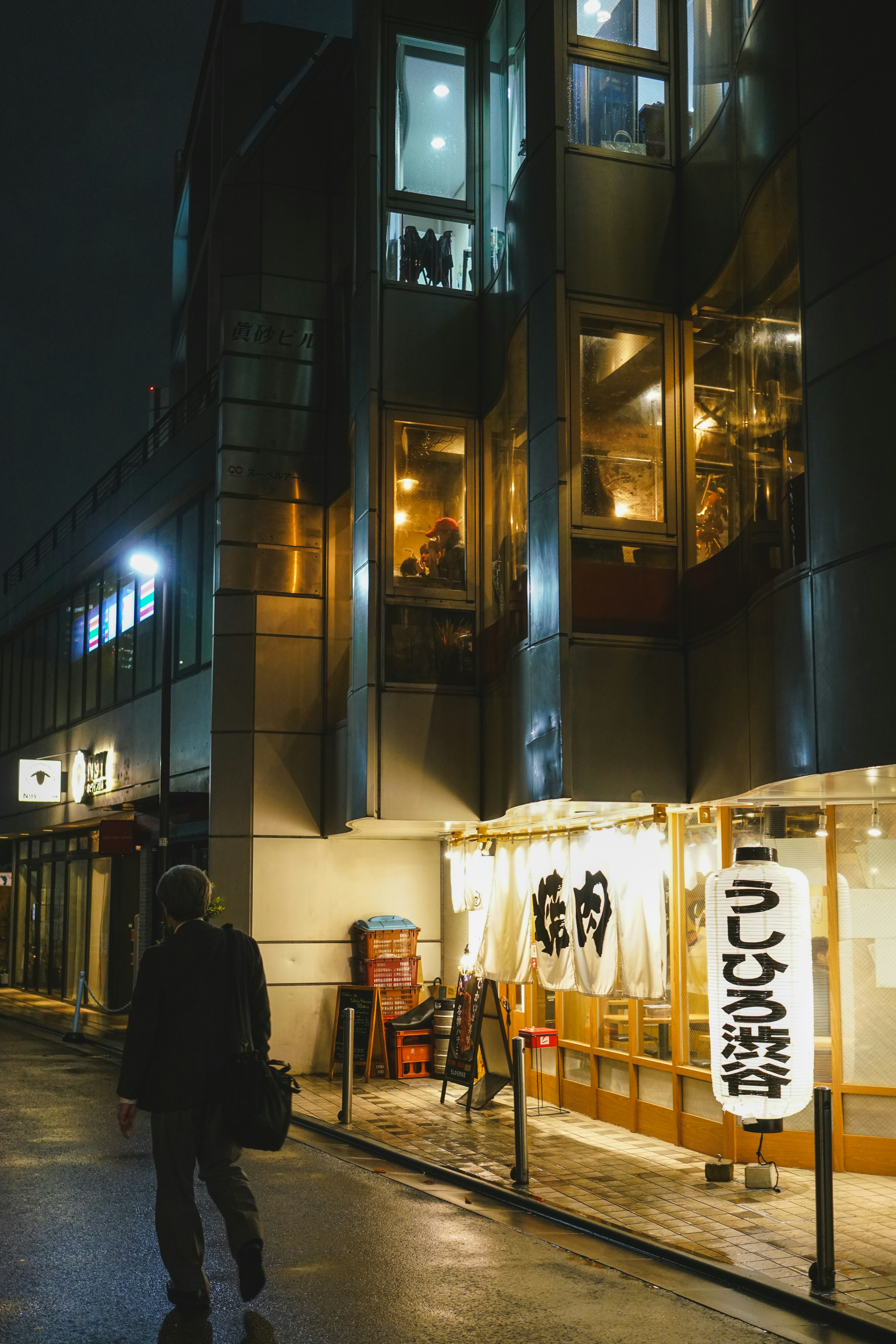 Ein Mann, der eine Straße neben einem hohen Gebäude entlanggeht