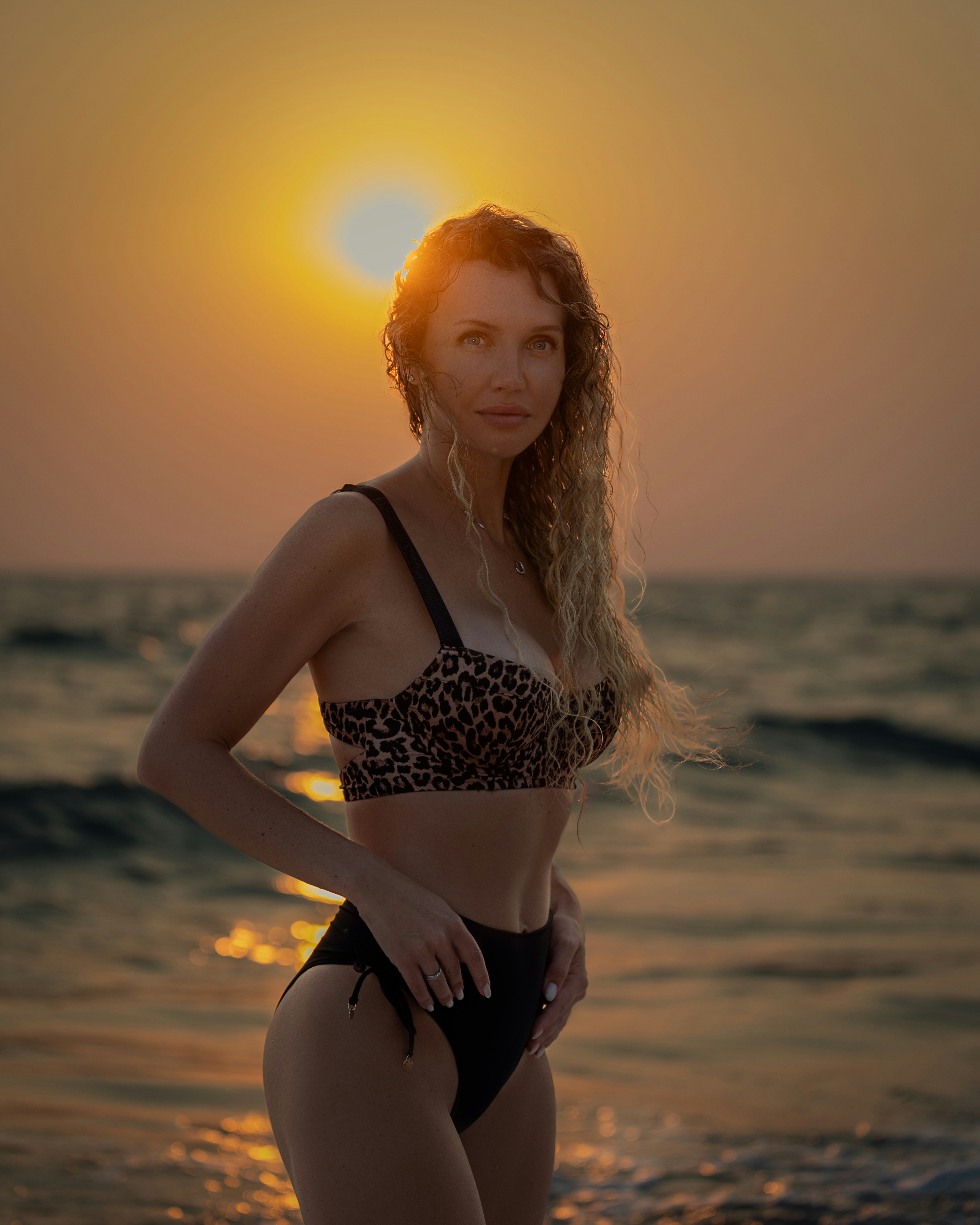a woman in a bikini standing on the beach