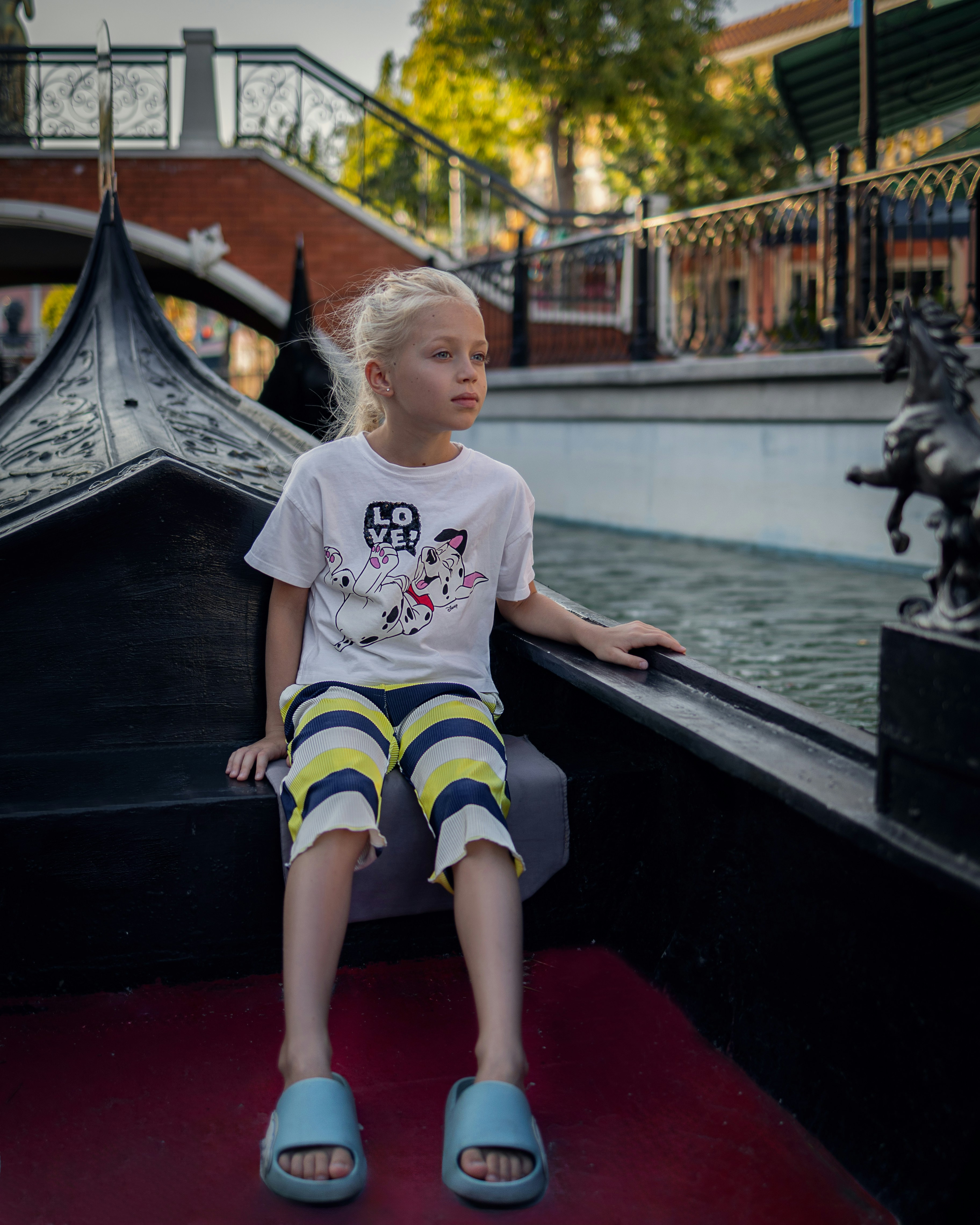 a little girl sitting on the edge of a boat