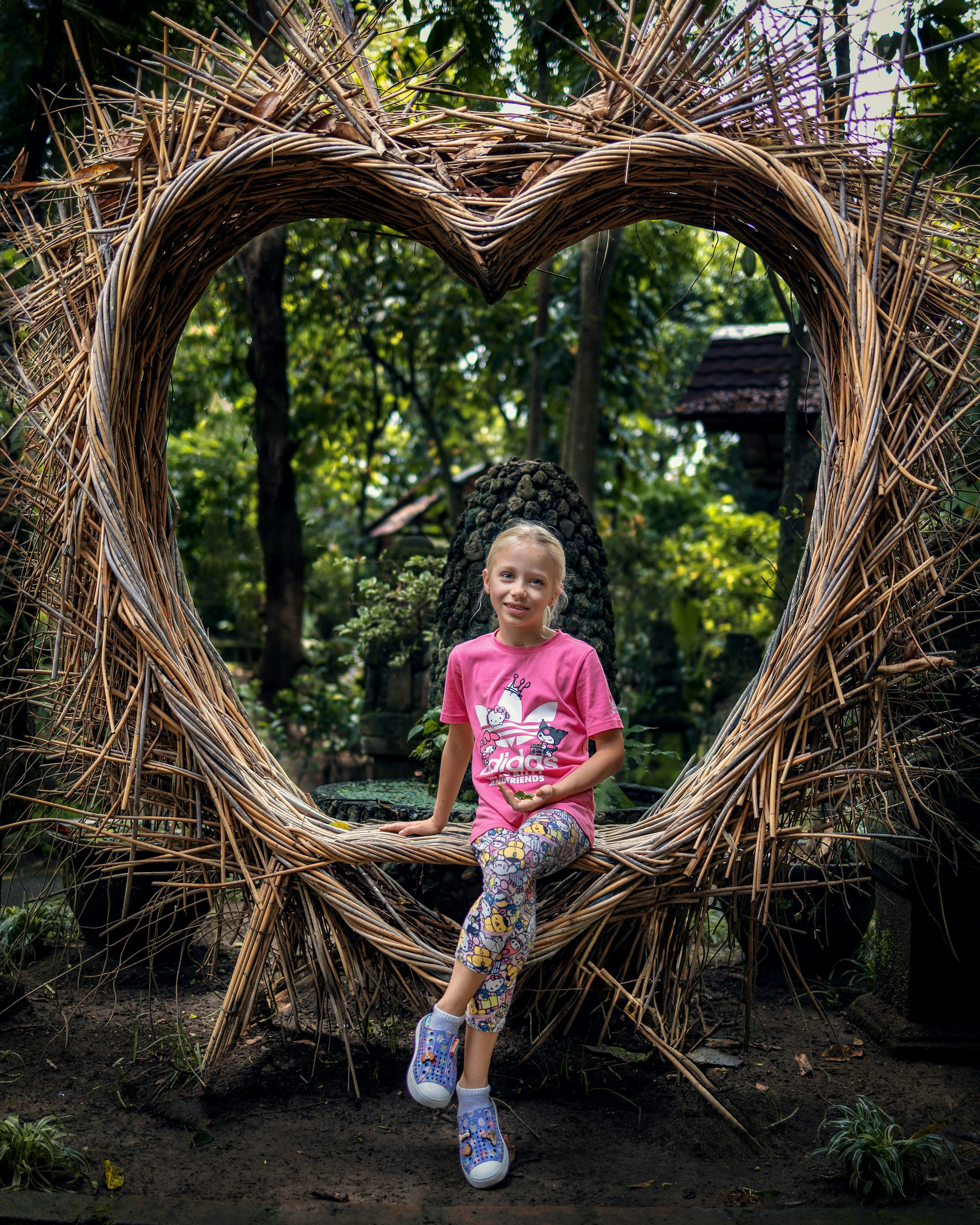 a little girl sitting in a heart shaped frame