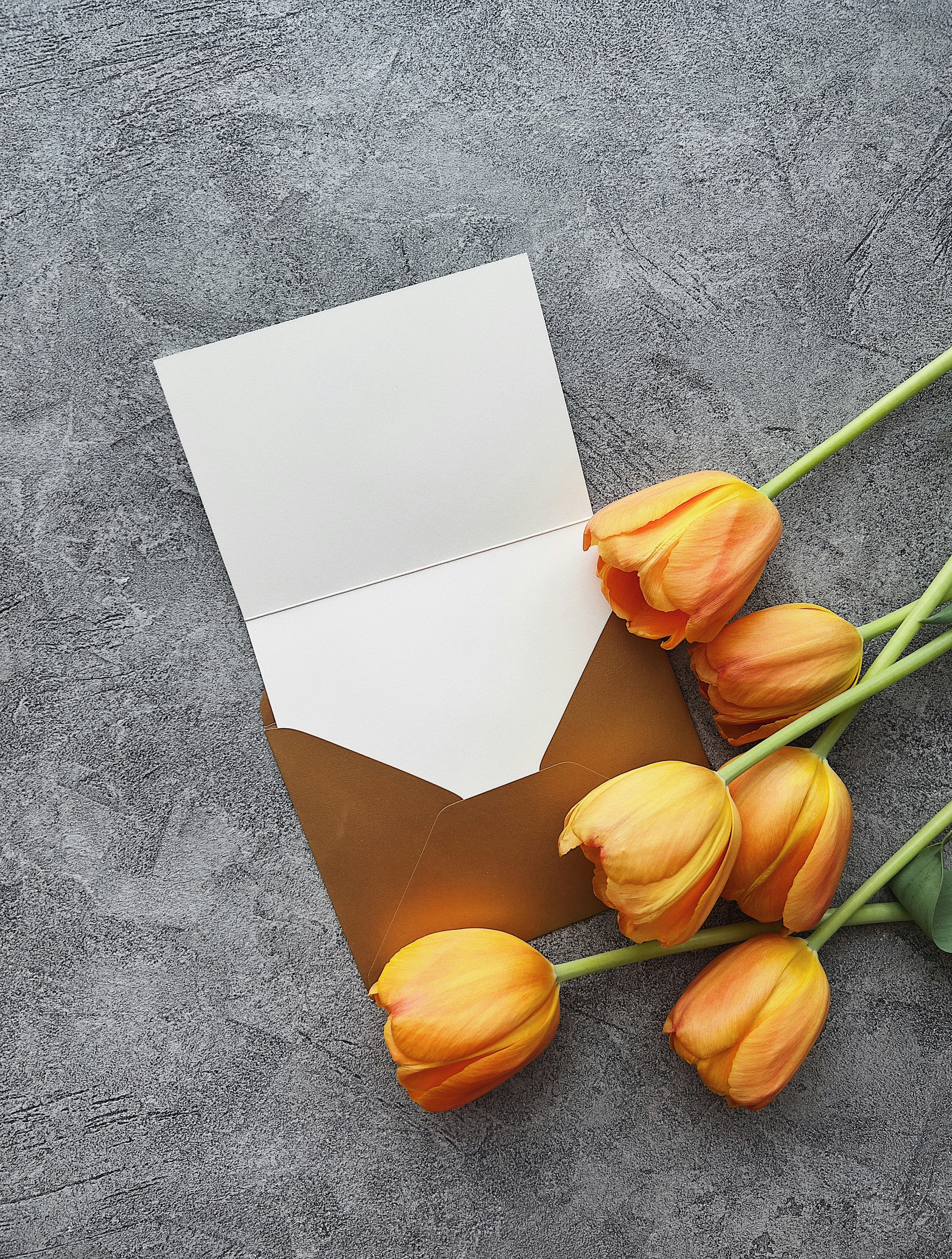 a bunch of yellow tulips sitting next to an envelope