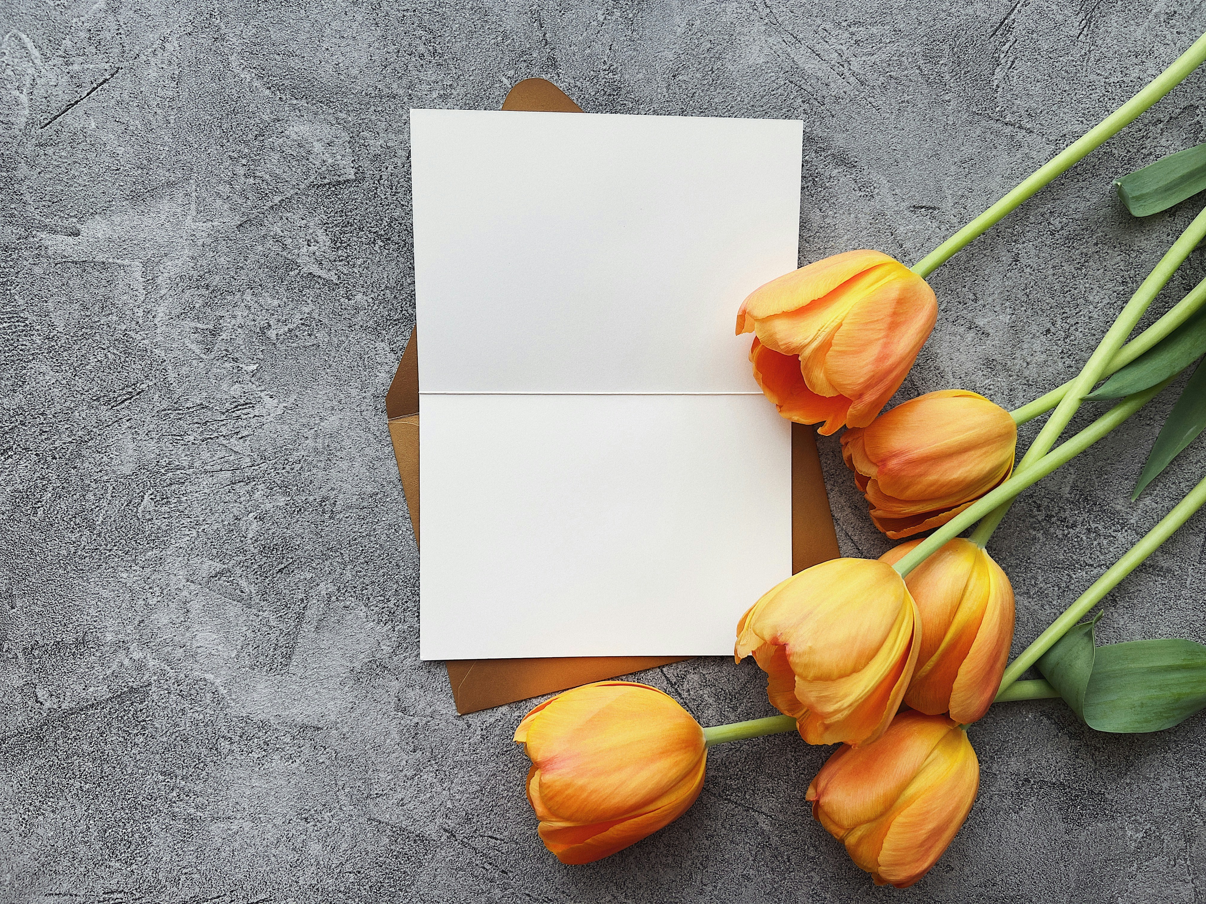 a bouquet of tulips next to a piece of paper