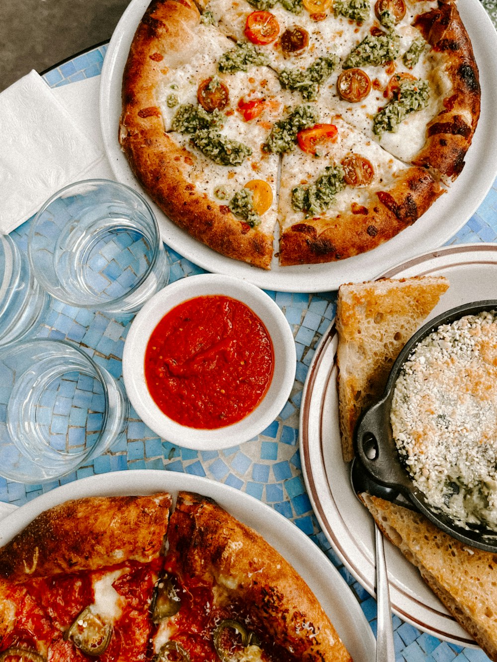 una mesa cubierta con platos de pizza y bebidas