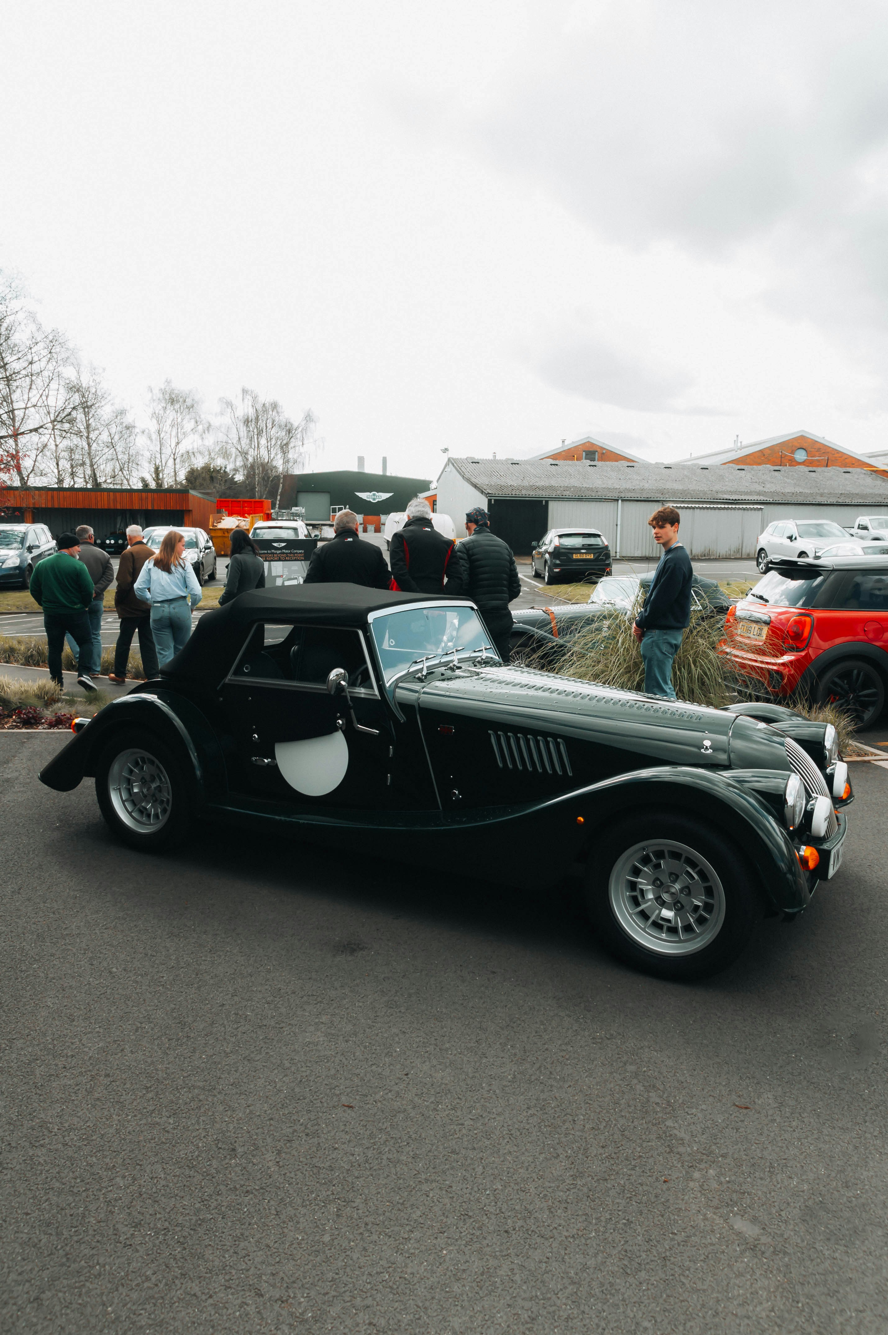a black car parked in a parking lot next to other cars