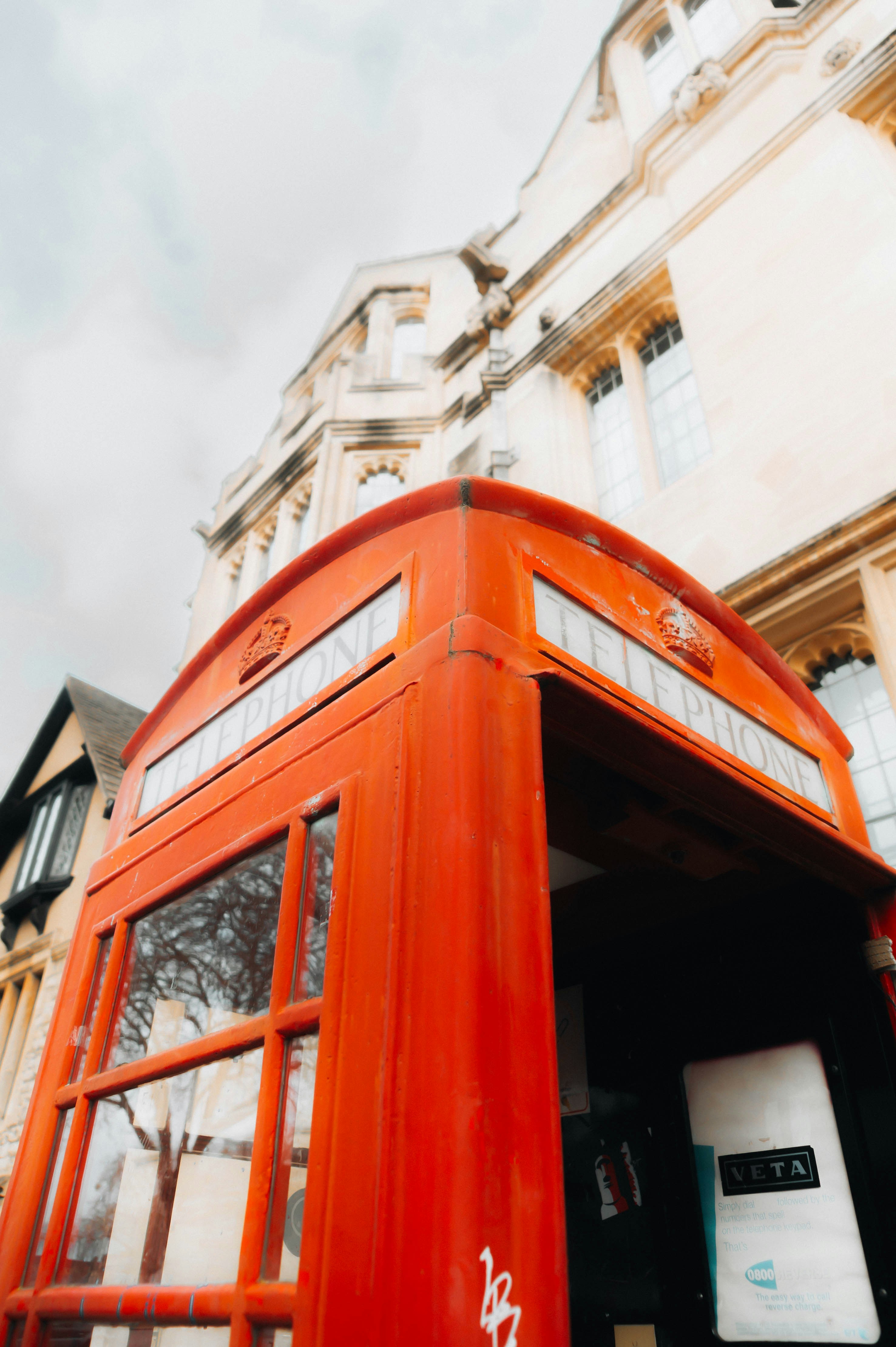 una cabina telefónica roja frente a un edificio alto