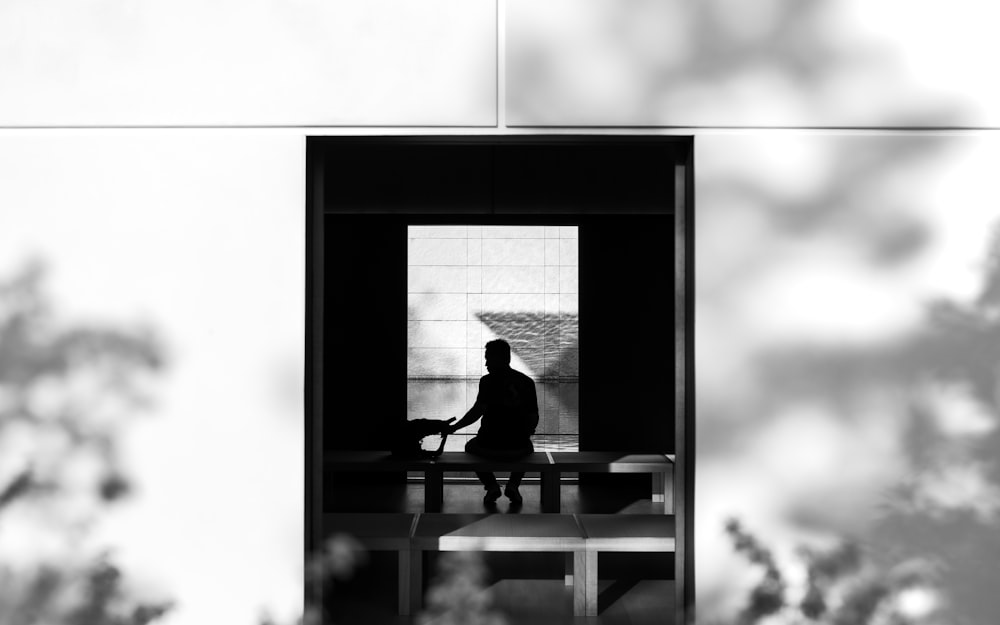 Una foto en blanco y negro de una persona sentada en una mesa