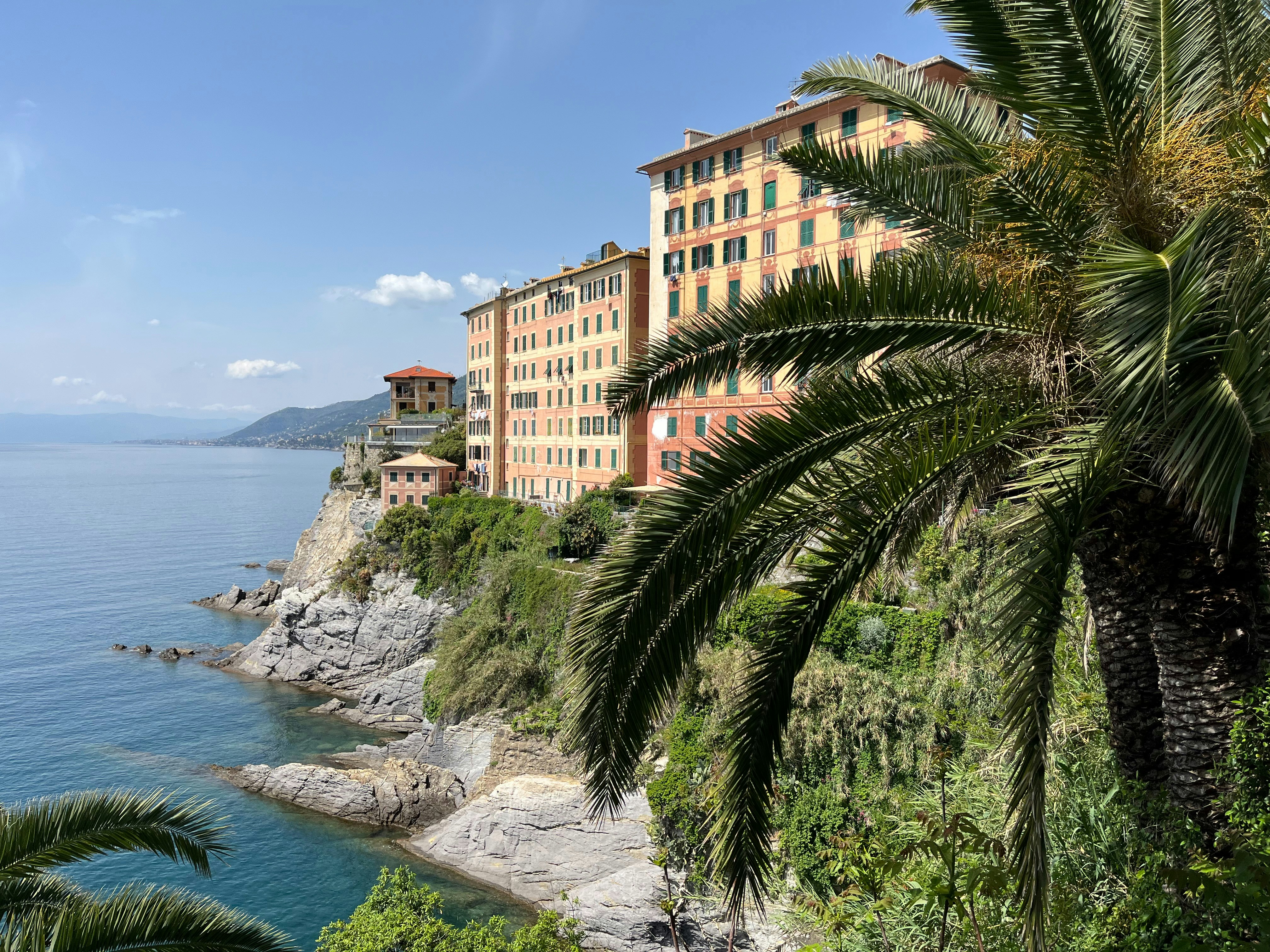 a row of buildings on the side of a cliff next to a body of water