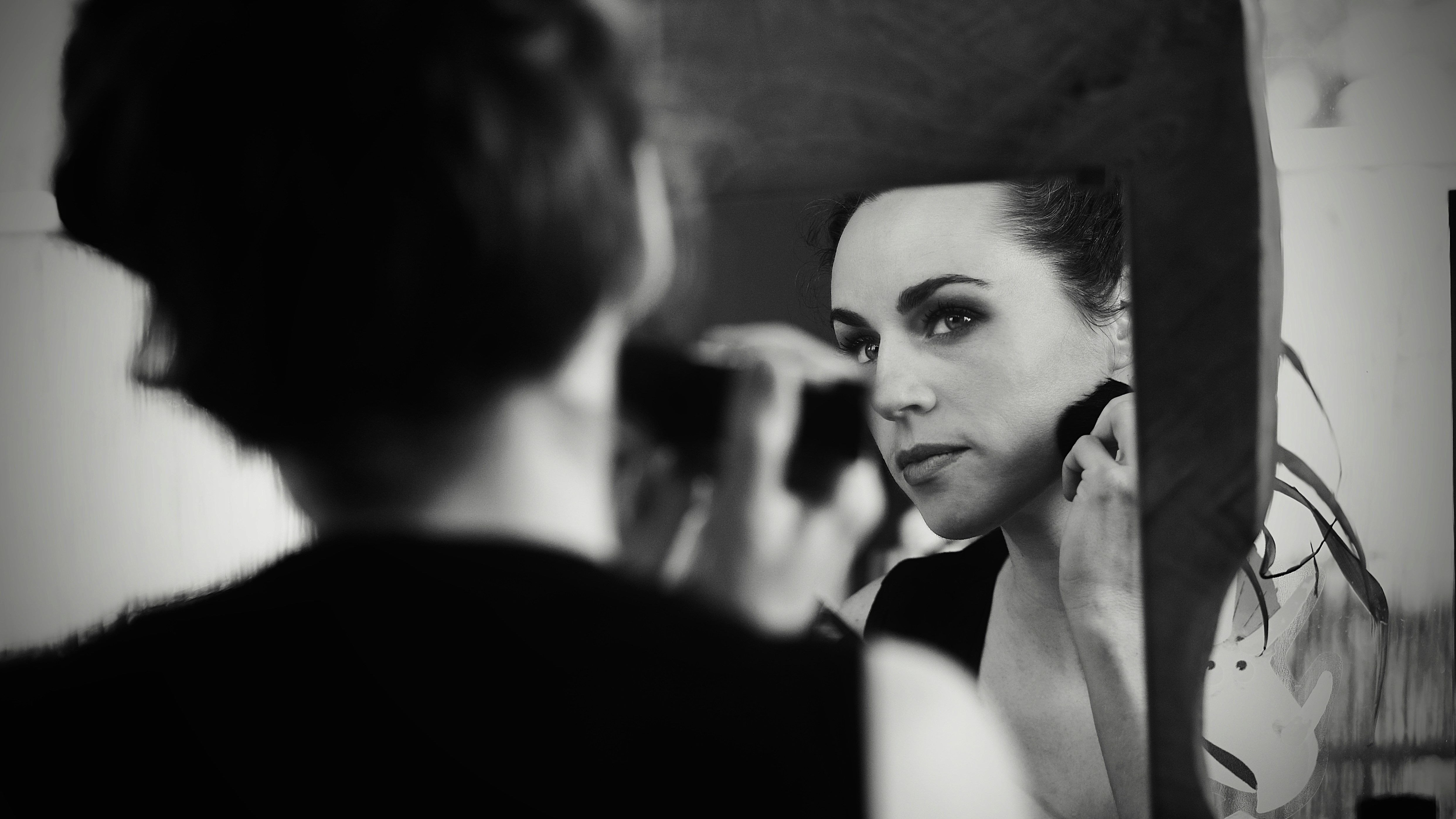 a woman is looking in the mirror while brushing her teeth