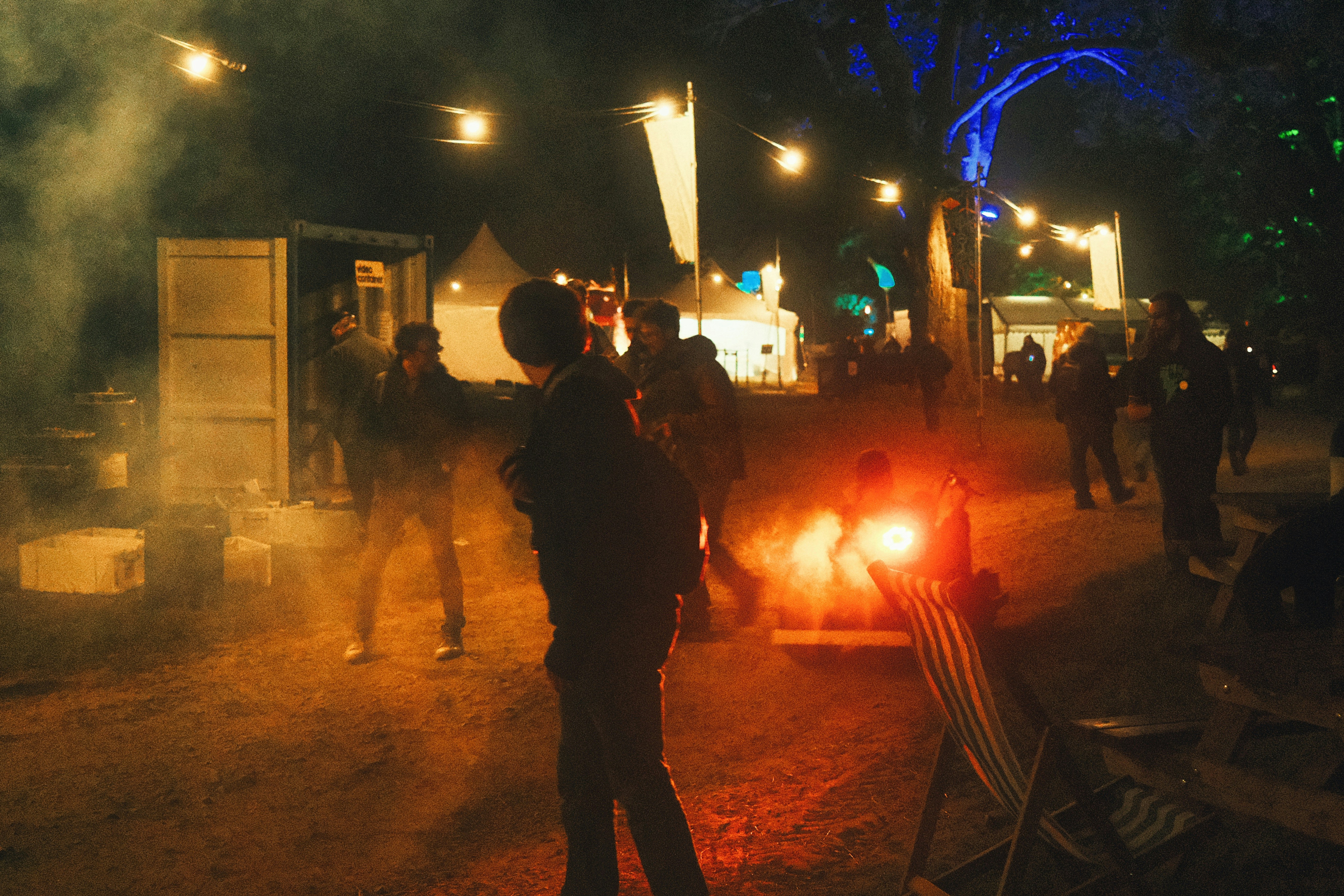 un groupe de personnes debout autour d’un feu de camp