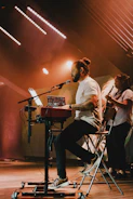 a man sitting in a chair while playing a keyboard