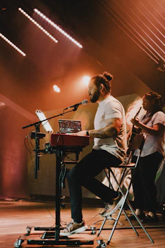 a man sitting in a chair while playing a keyboard