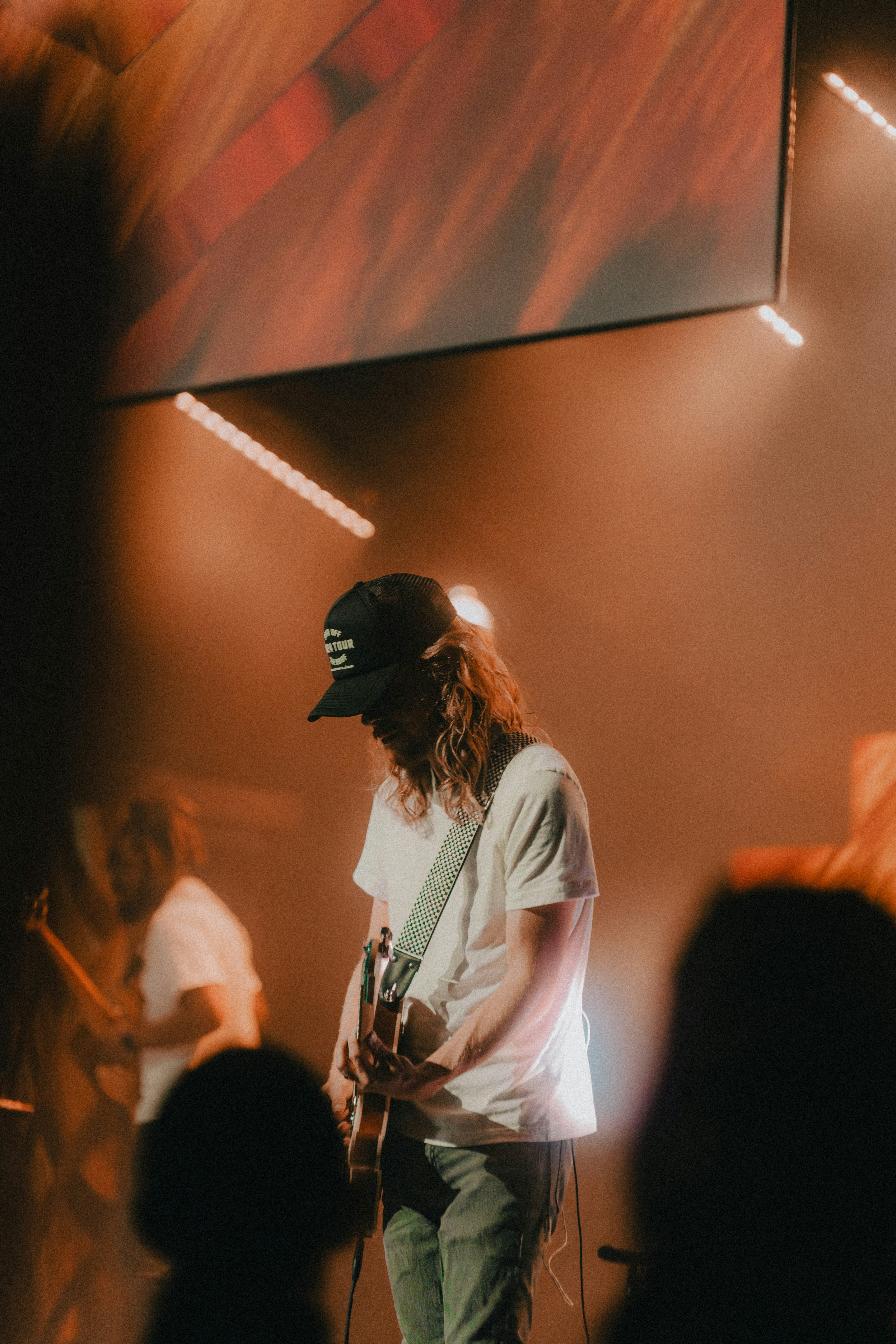 a man standing on a stage with a guitar