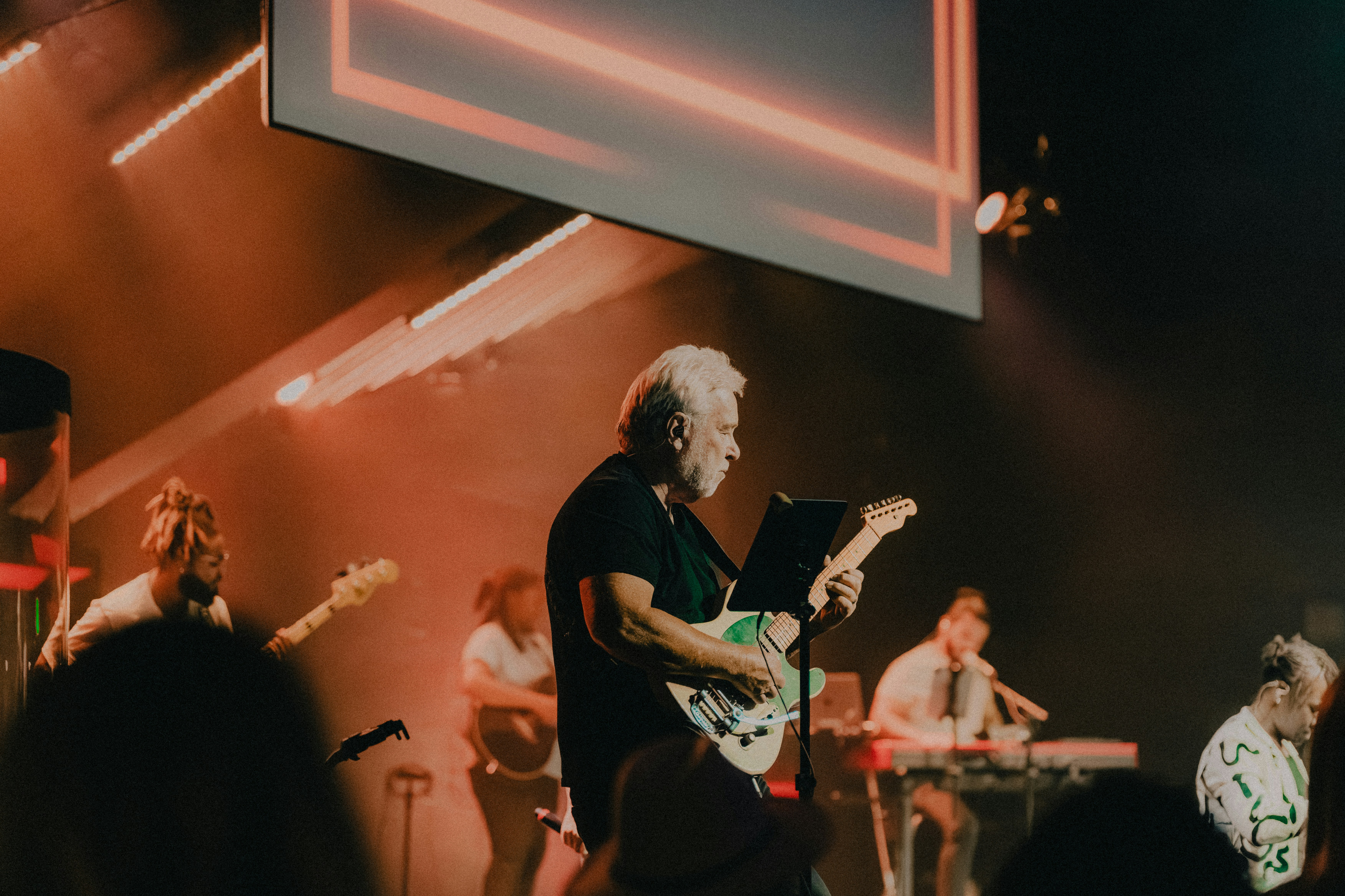 a man playing a guitar on a stage
