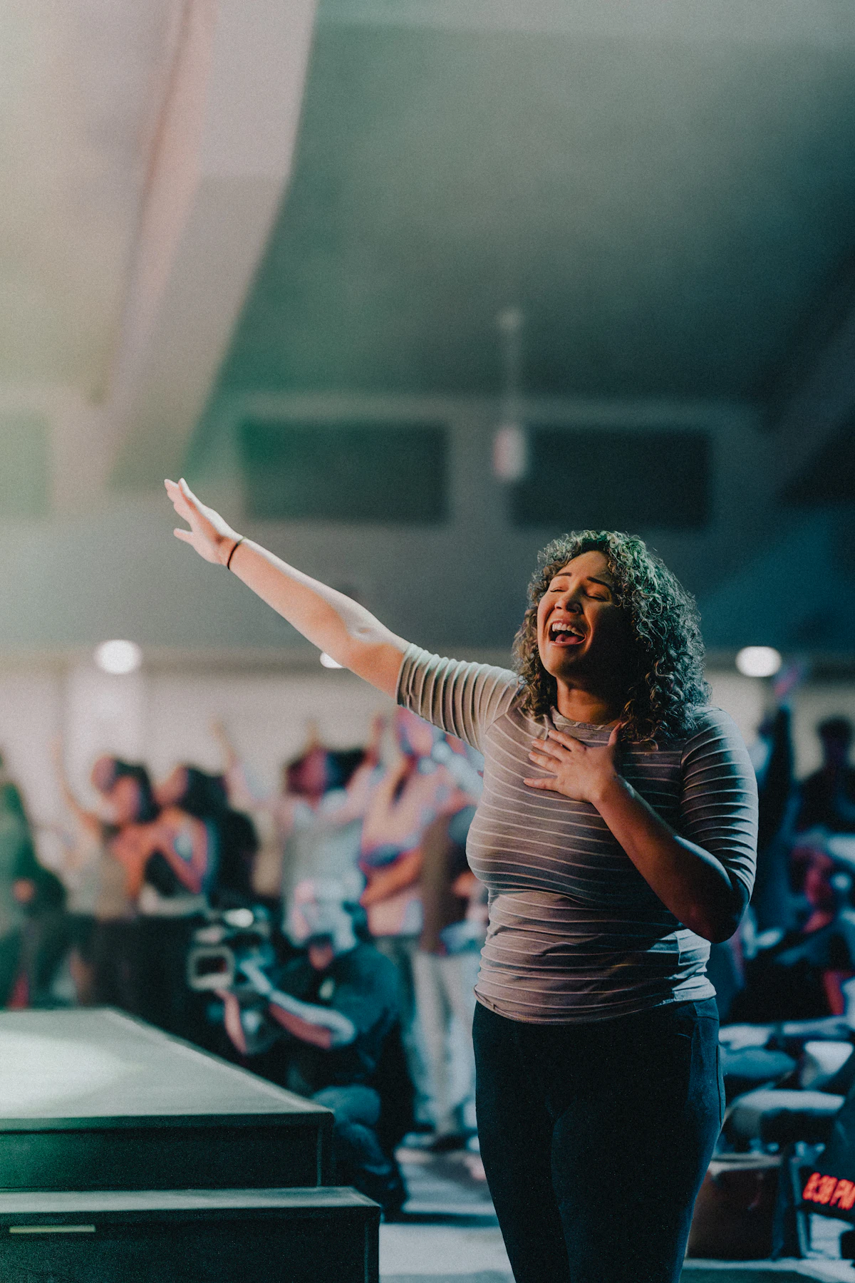 A woman standing before a crowd at a live event