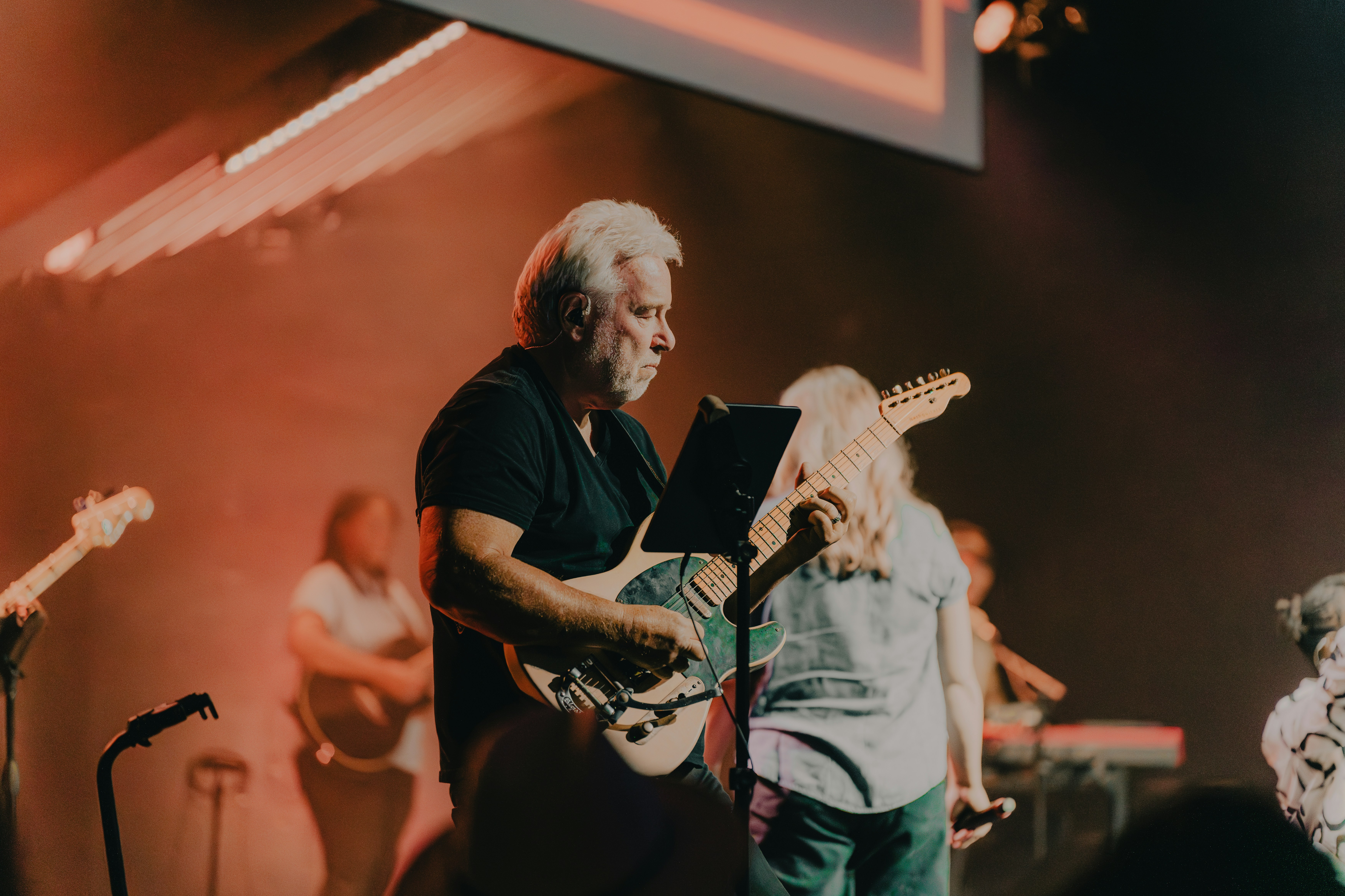 a man playing a guitar on a stage