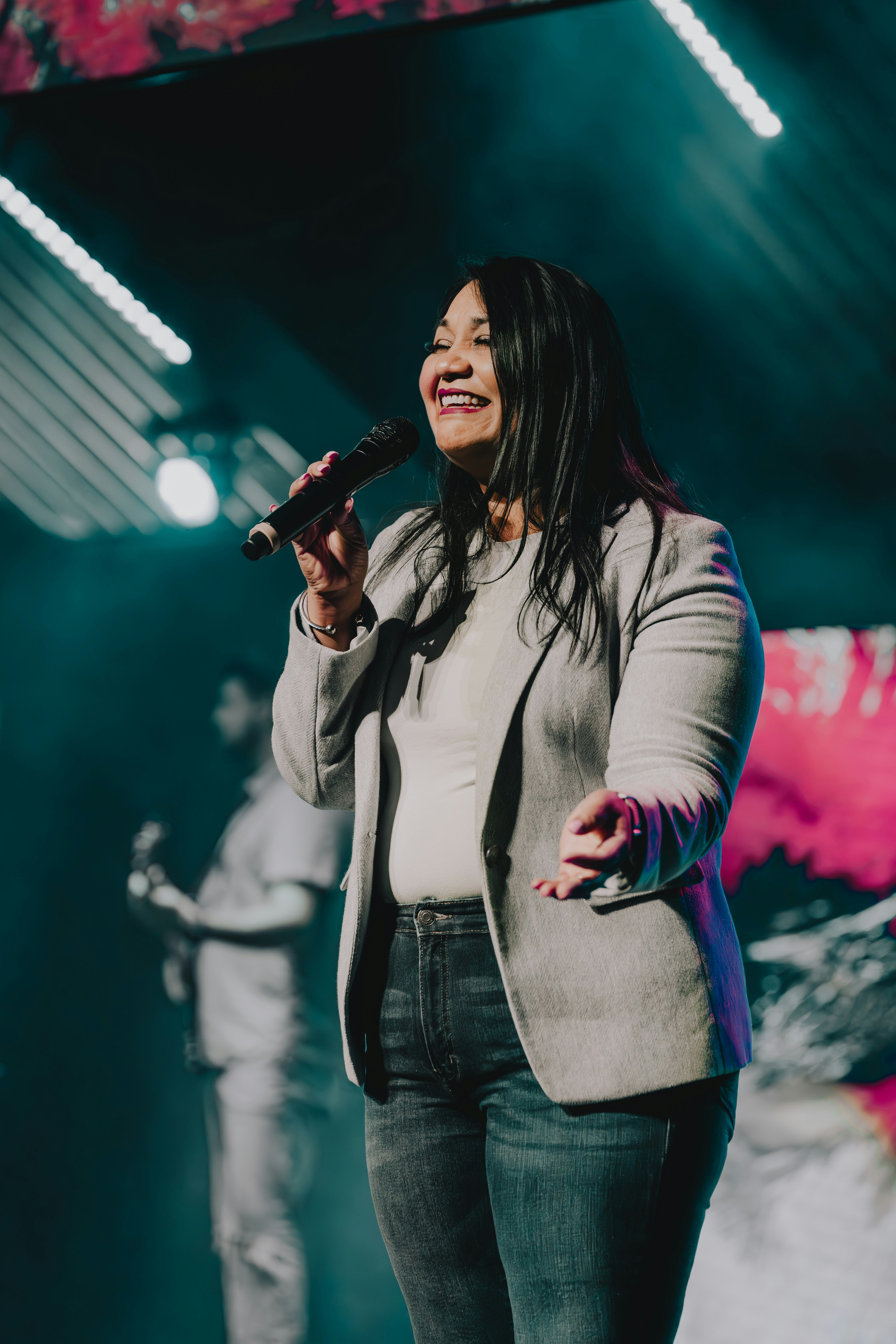 a woman singing into a microphone on stage