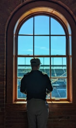 a man standing in front of a window looking out