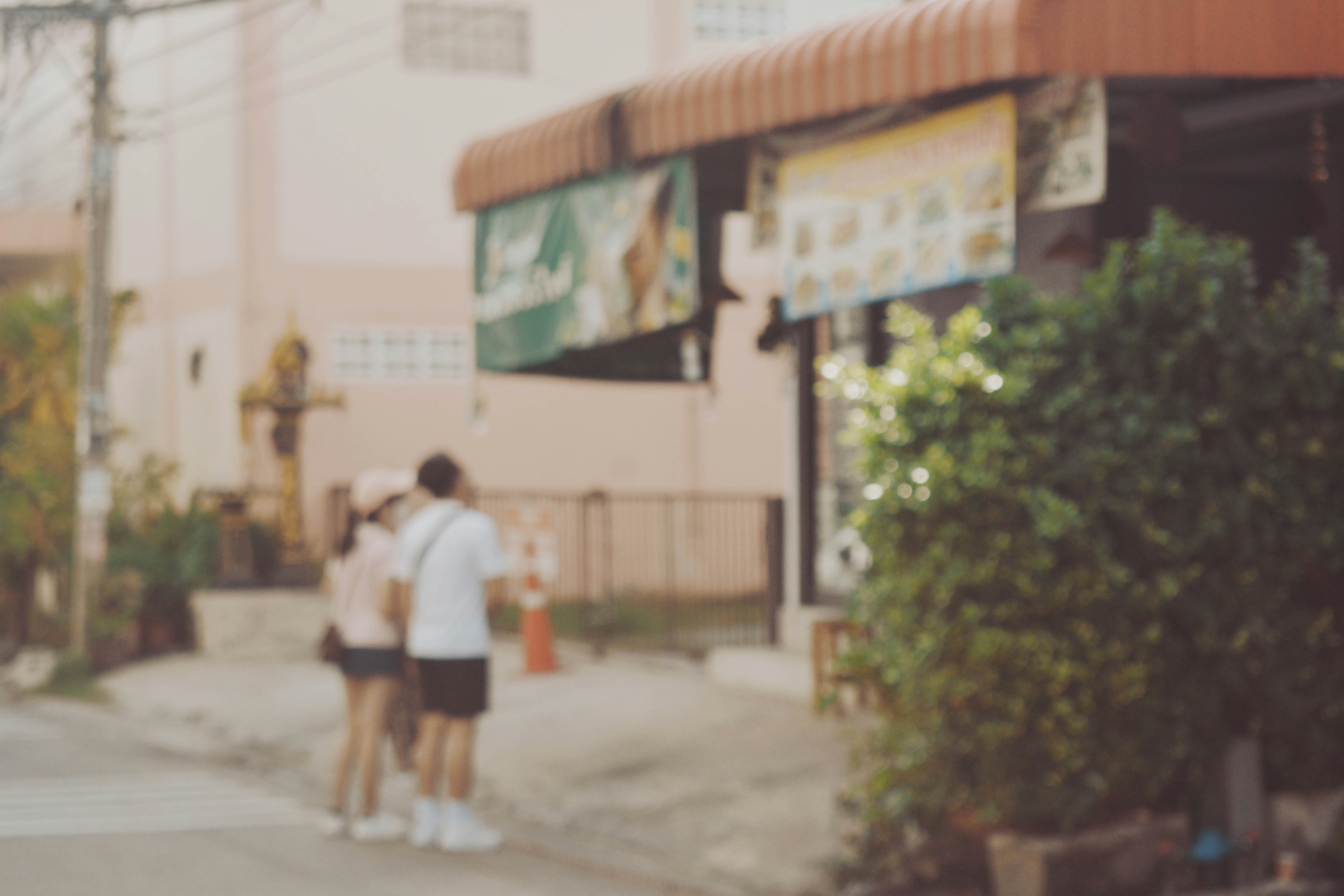 a blurry photo of two people standing on a street corner