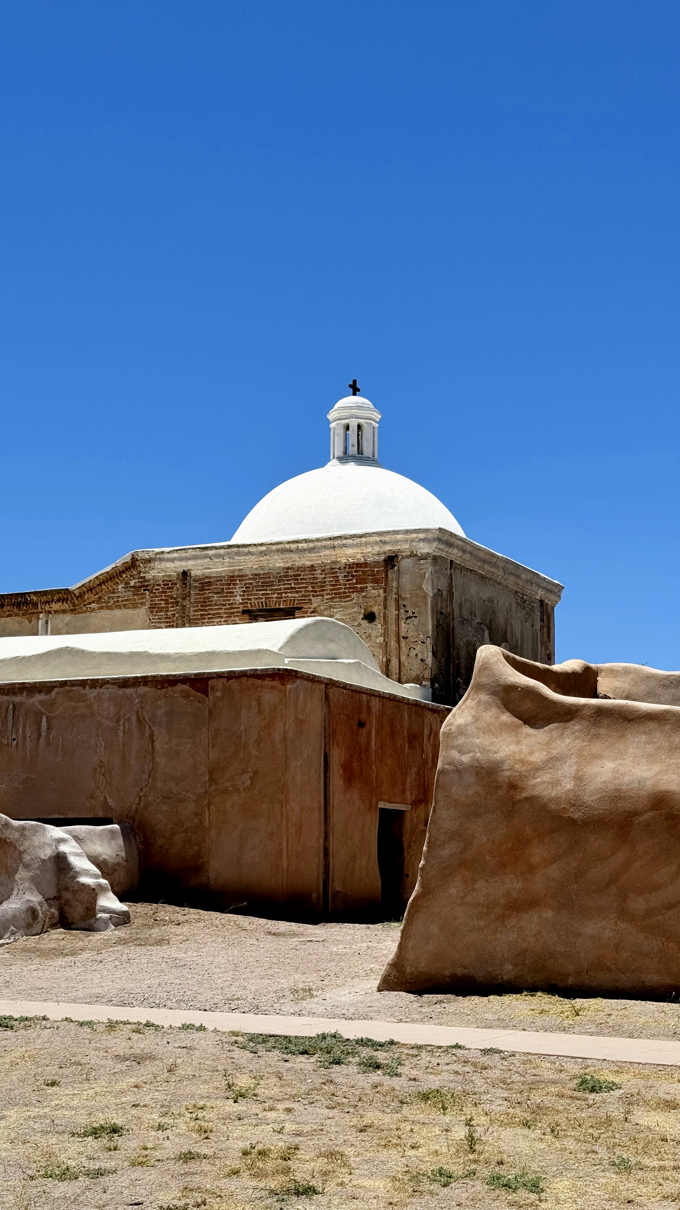 a building with a dome and a rock in front of it