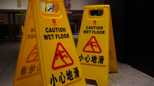 a couple of yellow caution signs sitting on top of a floor