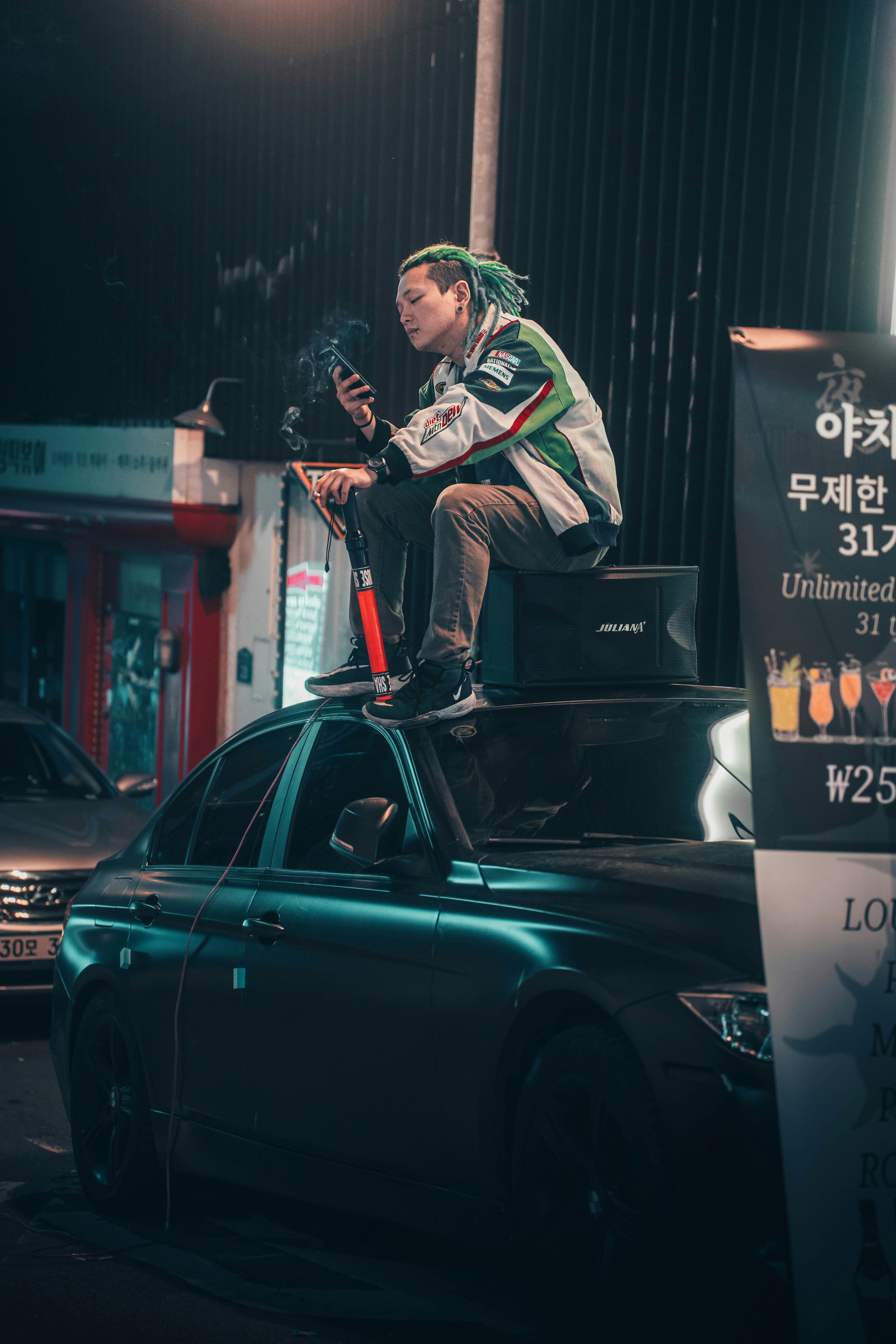 a man sitting on top of a black car