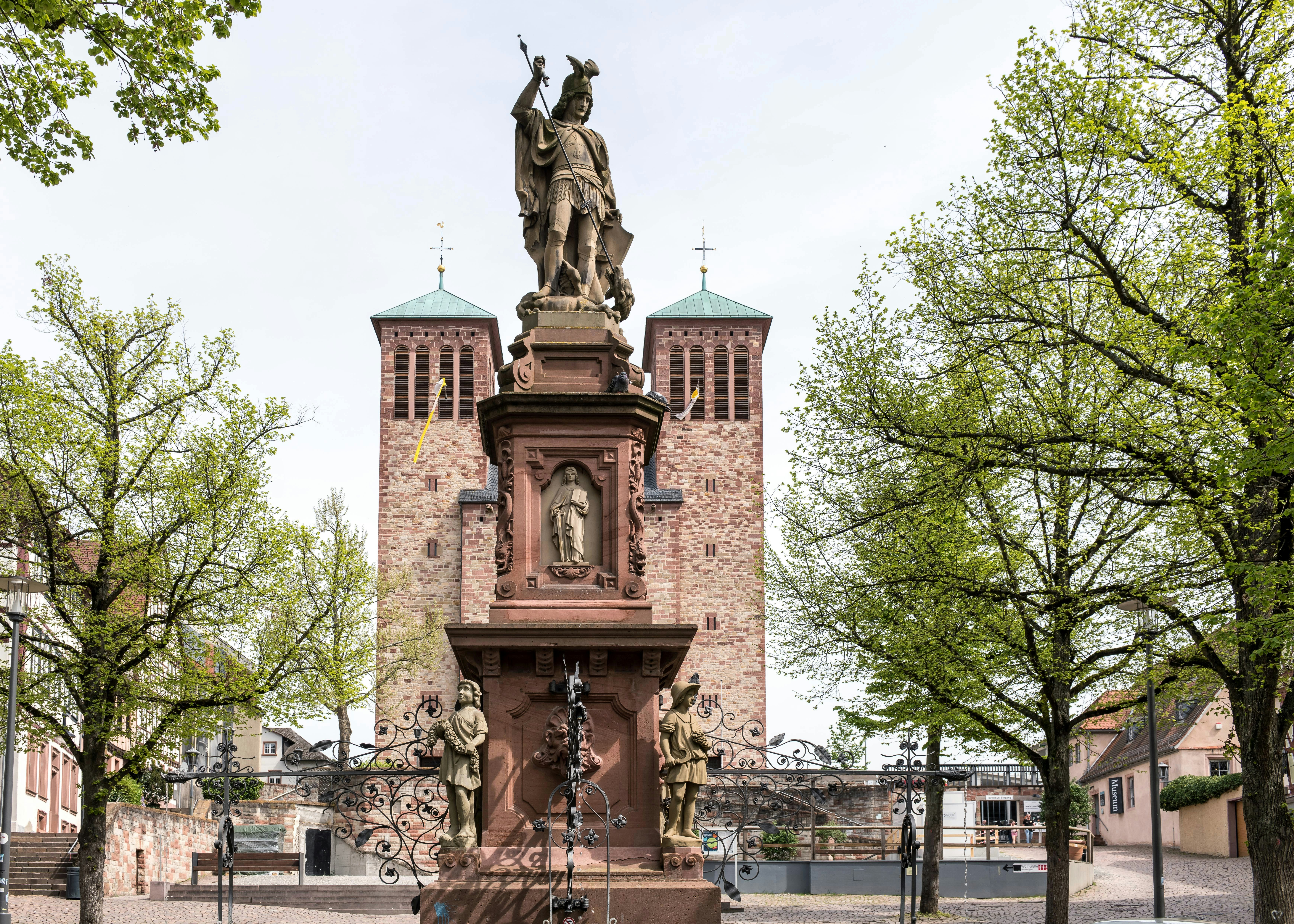 eine Statue eines Mannes auf der Spitze eines Uhrenturms