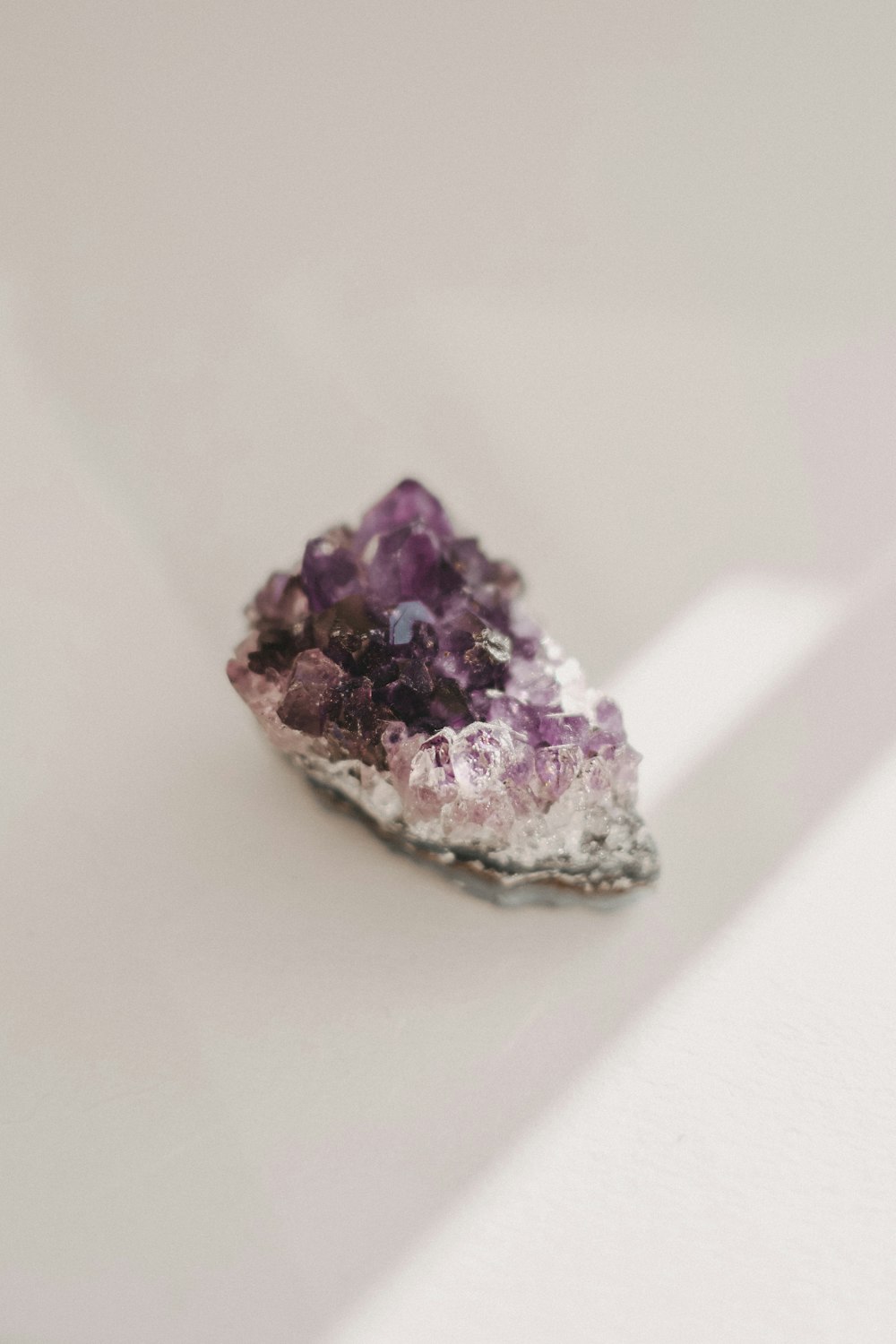 a cluster of purple crystals sitting on top of a white table