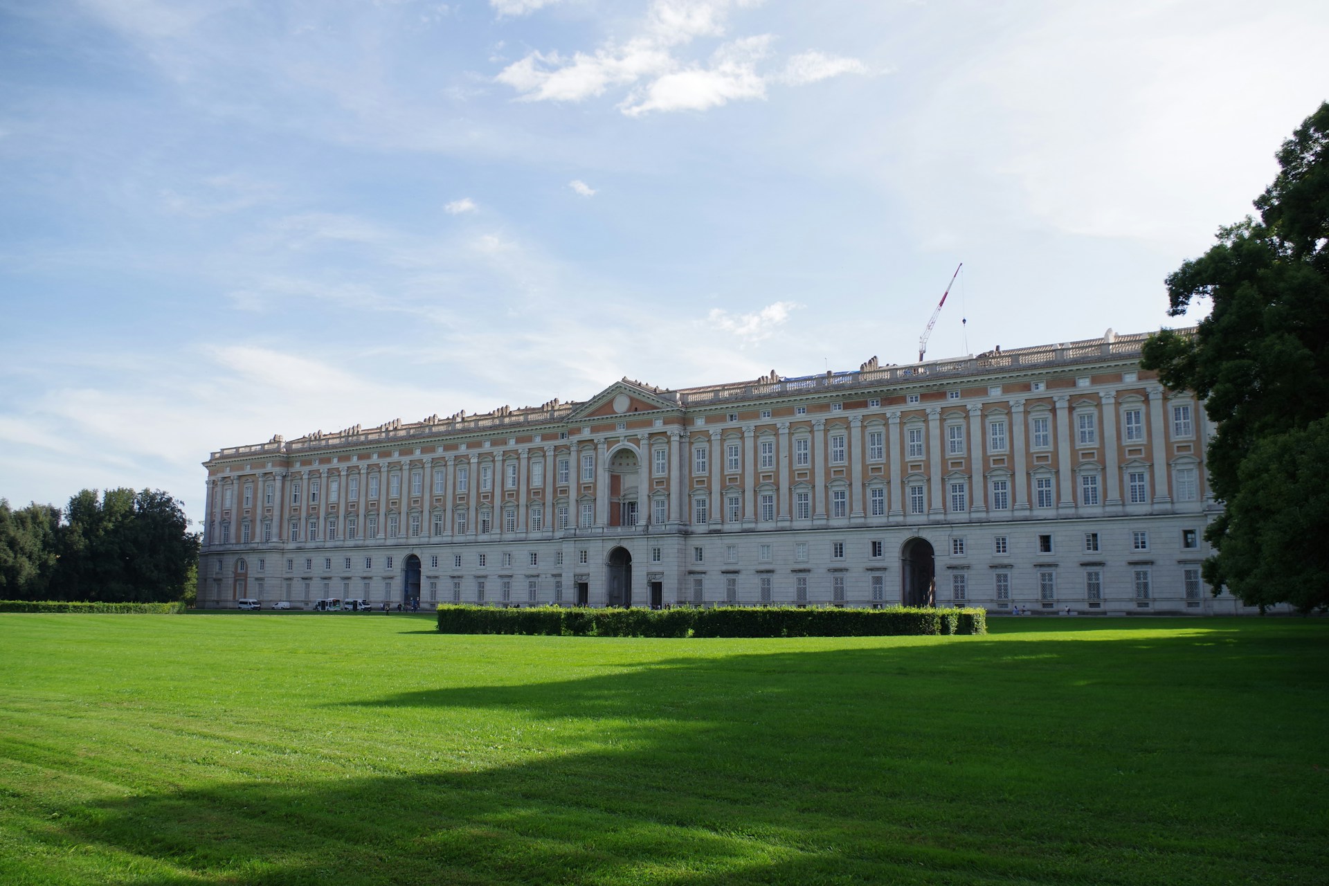 a large white building sitting on top of a lush green field