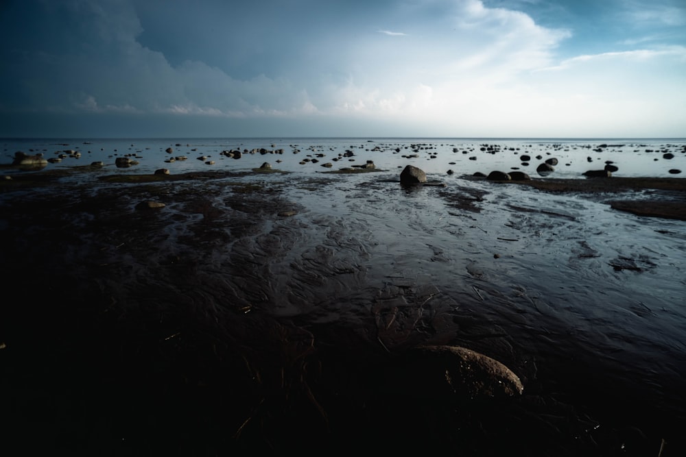 un cuerpo de agua rodeado de rocas bajo un cielo nublado