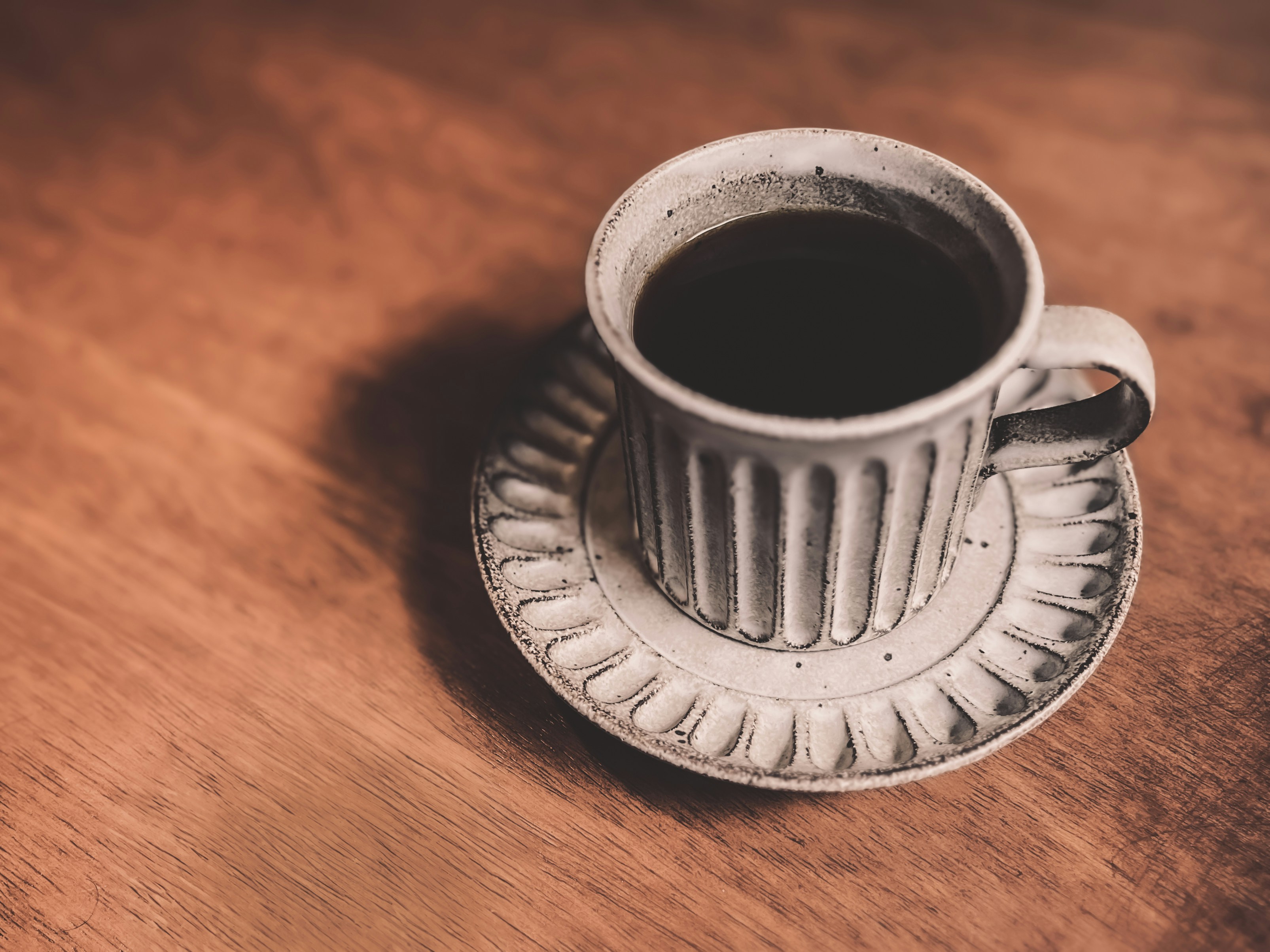 White ceramic coffee set on wooden table, warm light