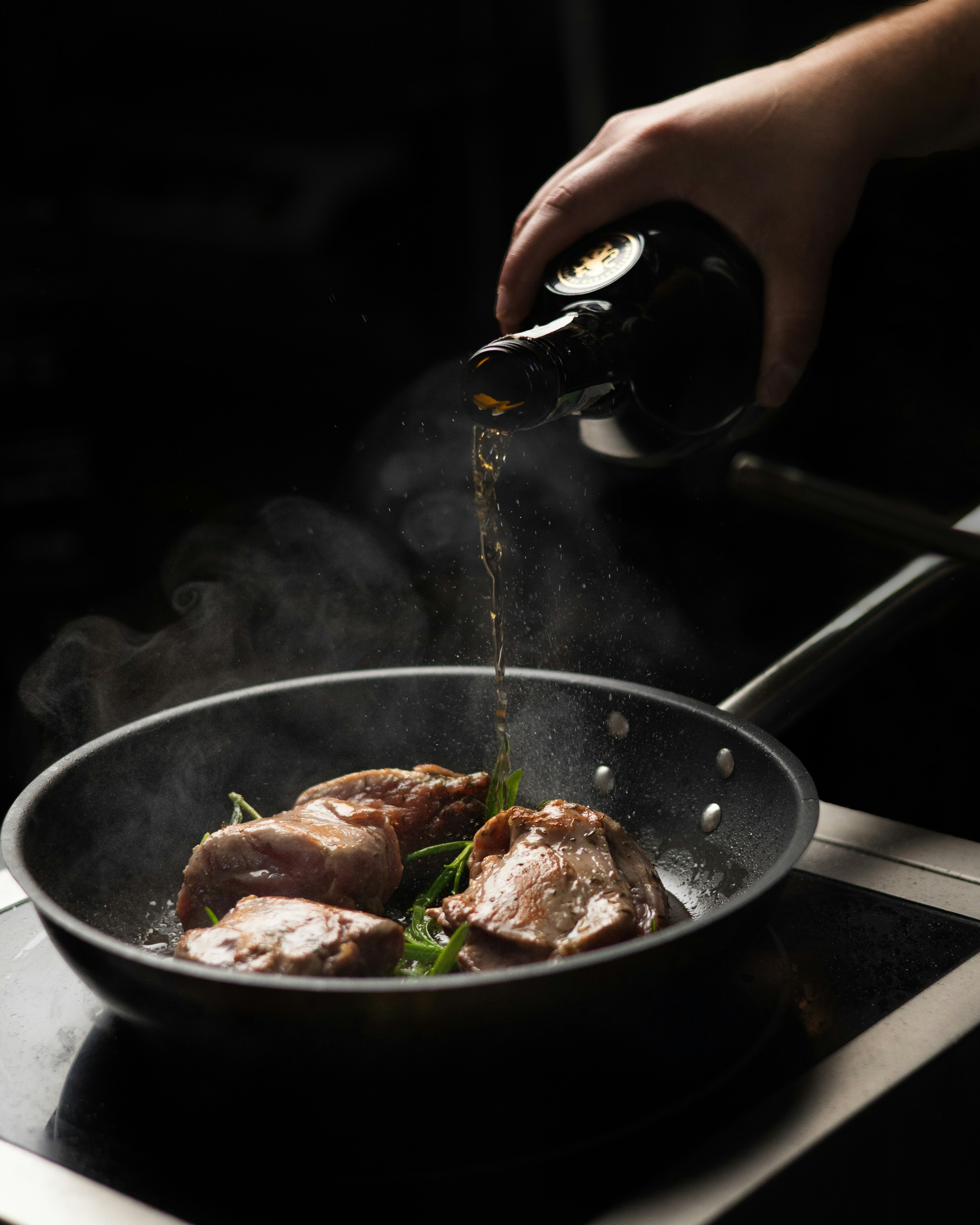a person cooking meat in a pan on a stove