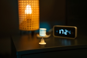 a table with a clock and a lamp on it