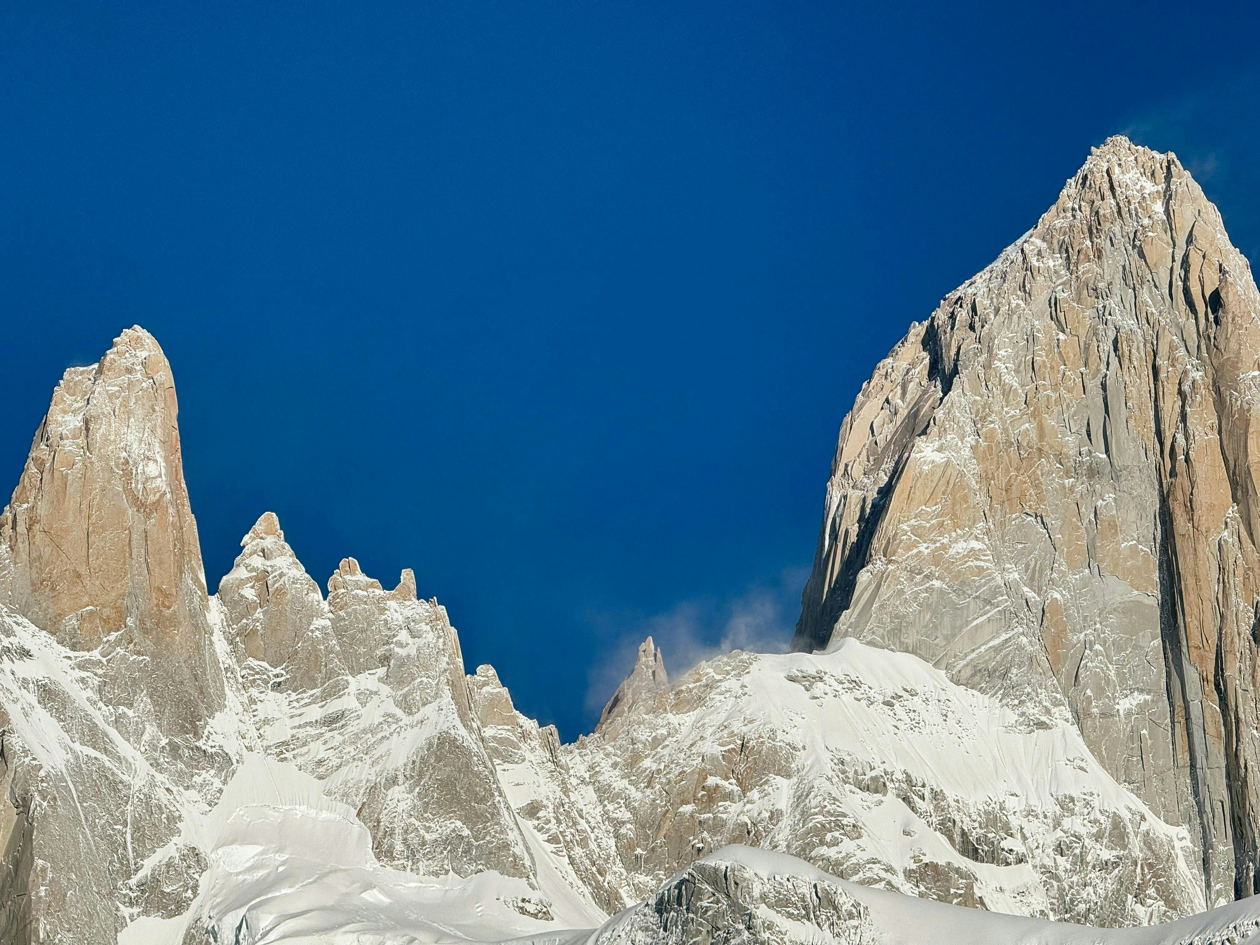 a group of snow covered mountains under a blue sky