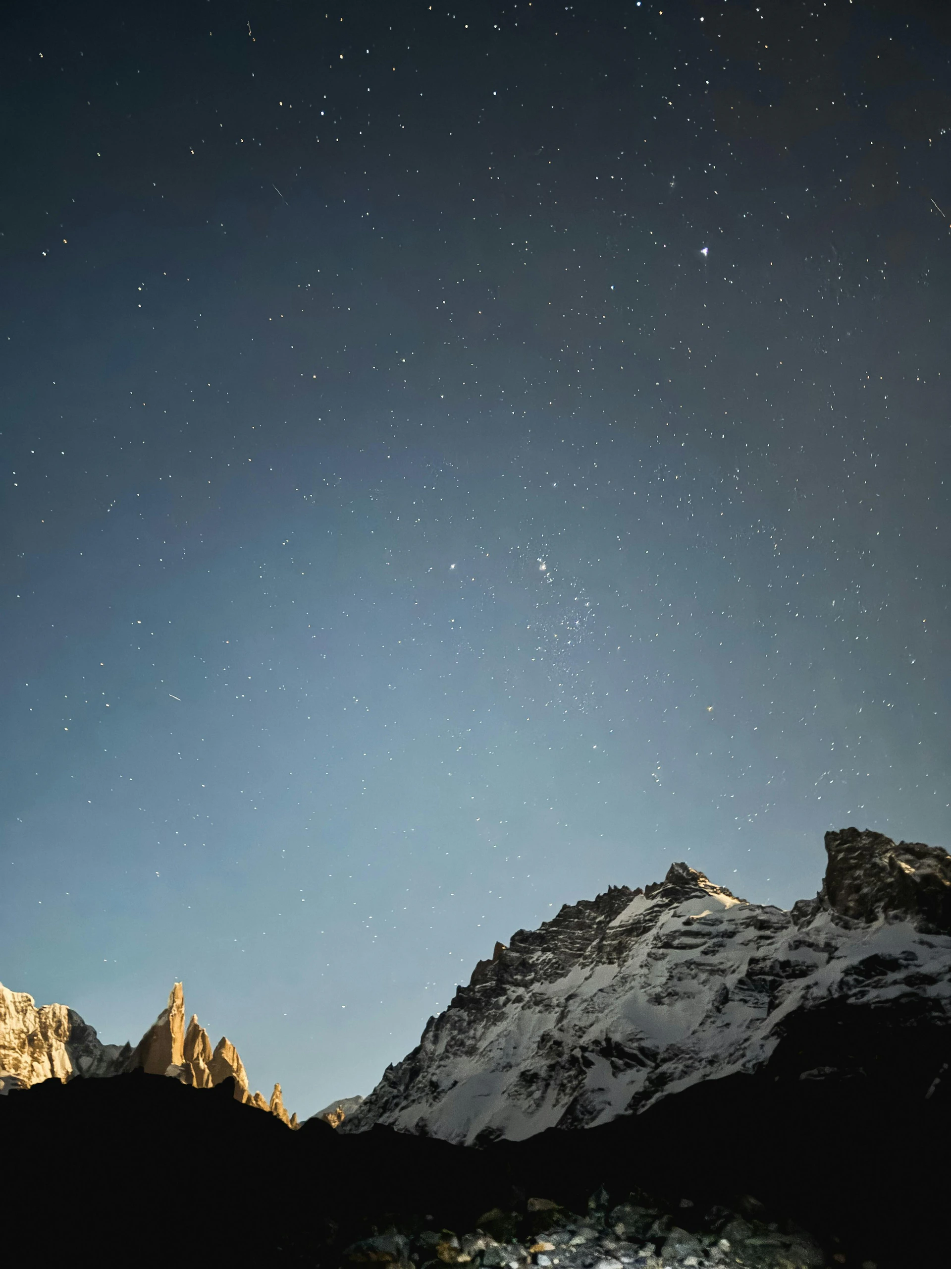 the night sky with stars above a mountain range