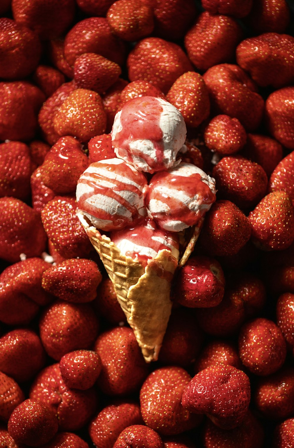 a pile of strawberries with a cone of ice cream