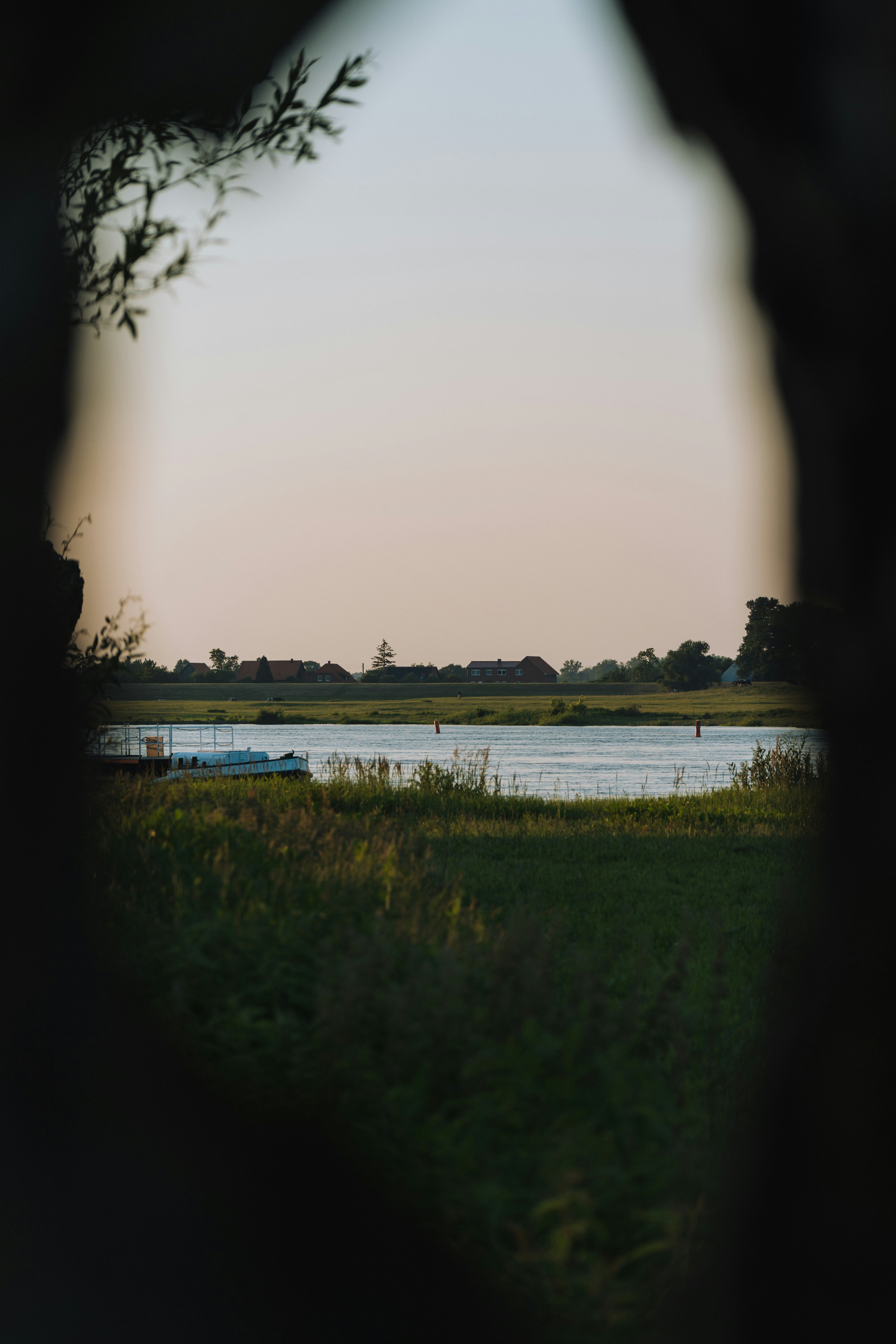 Un cuerpo de agua junto a un exuberante campo verde